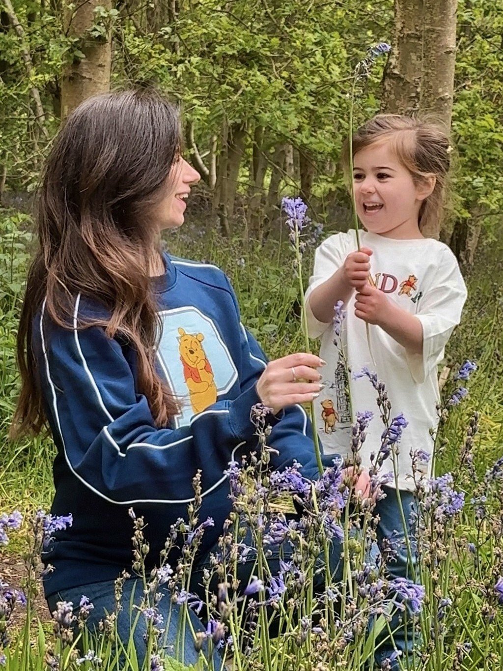 Mother and young daughter spending time together in a wildflower garden during spring.