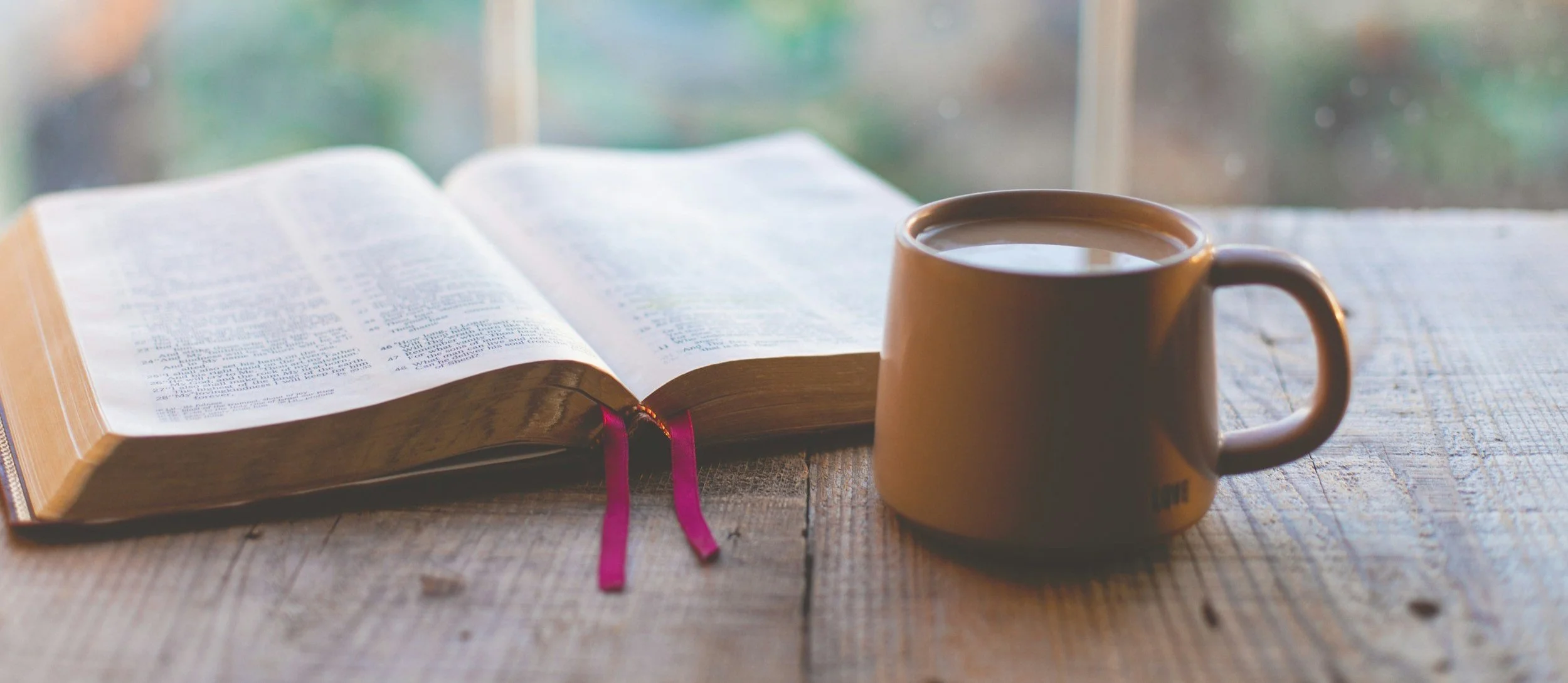 Open book and coffee on a table, representing financial insights and thought leadership across Wiltshire, the South West and London