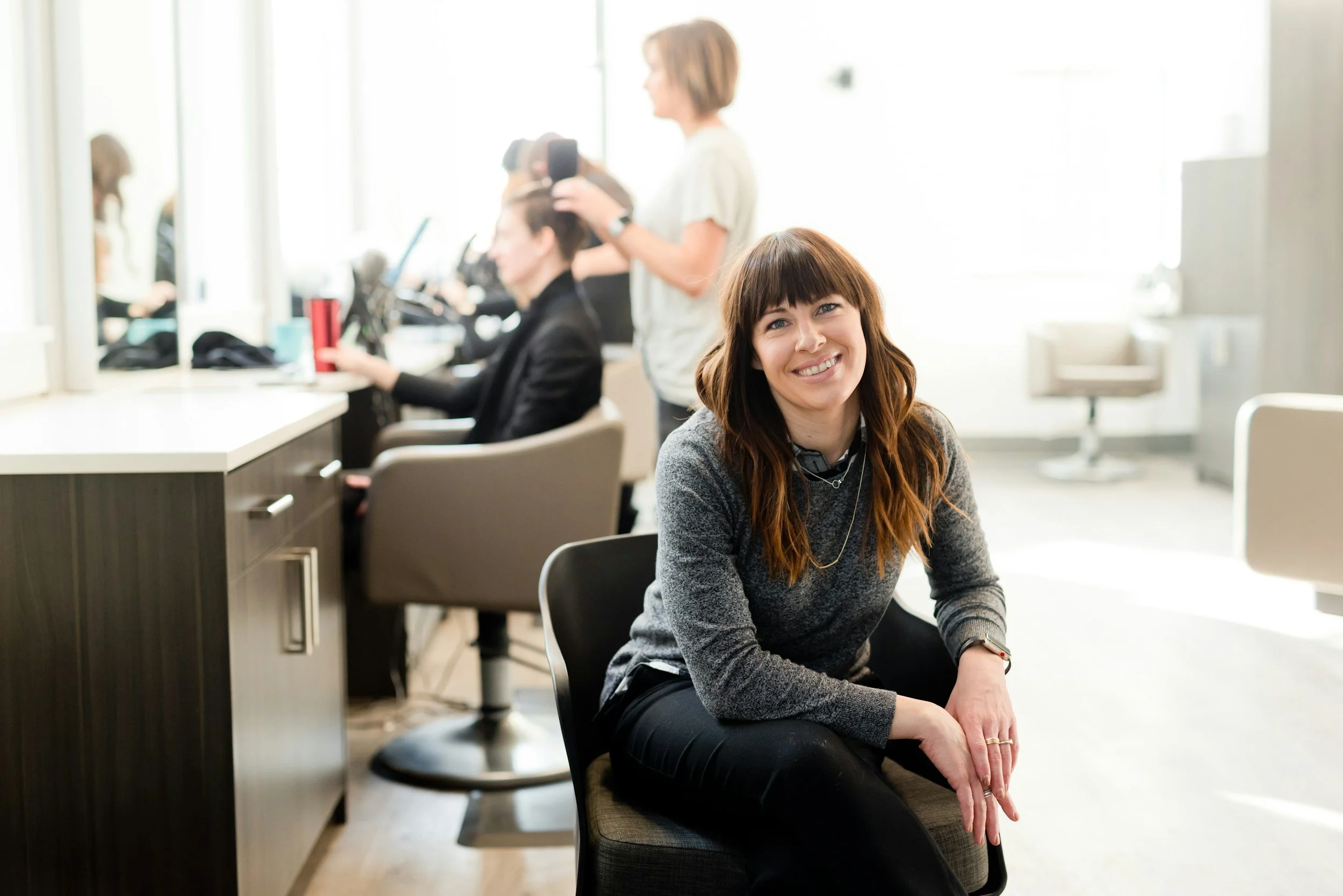 Small business owner in a salon environment, representing pension and retirement planning for business owners and long-term financial security