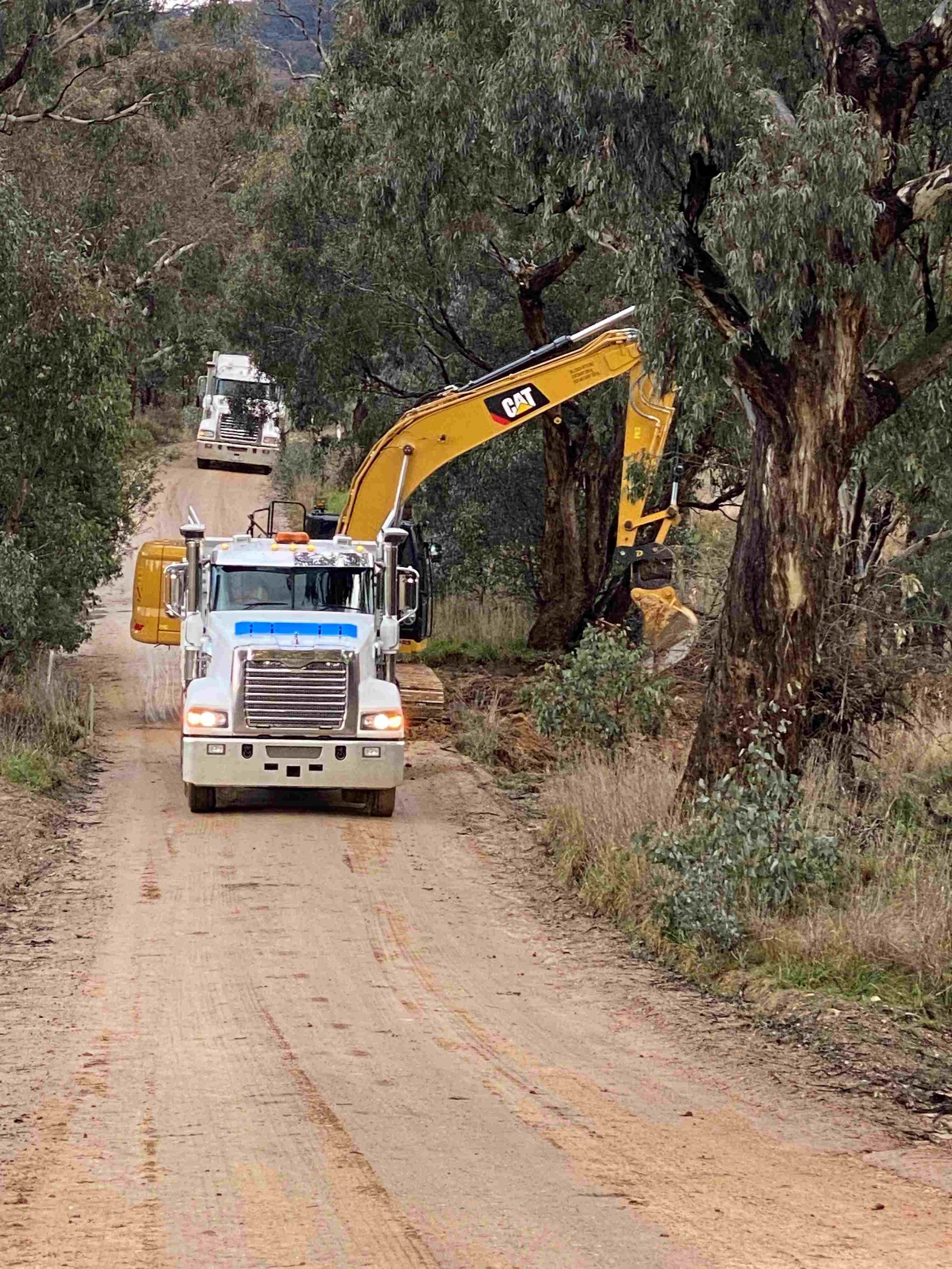 Excavation and truck operations clearing drainage channels for rural and commercial infrastructure
