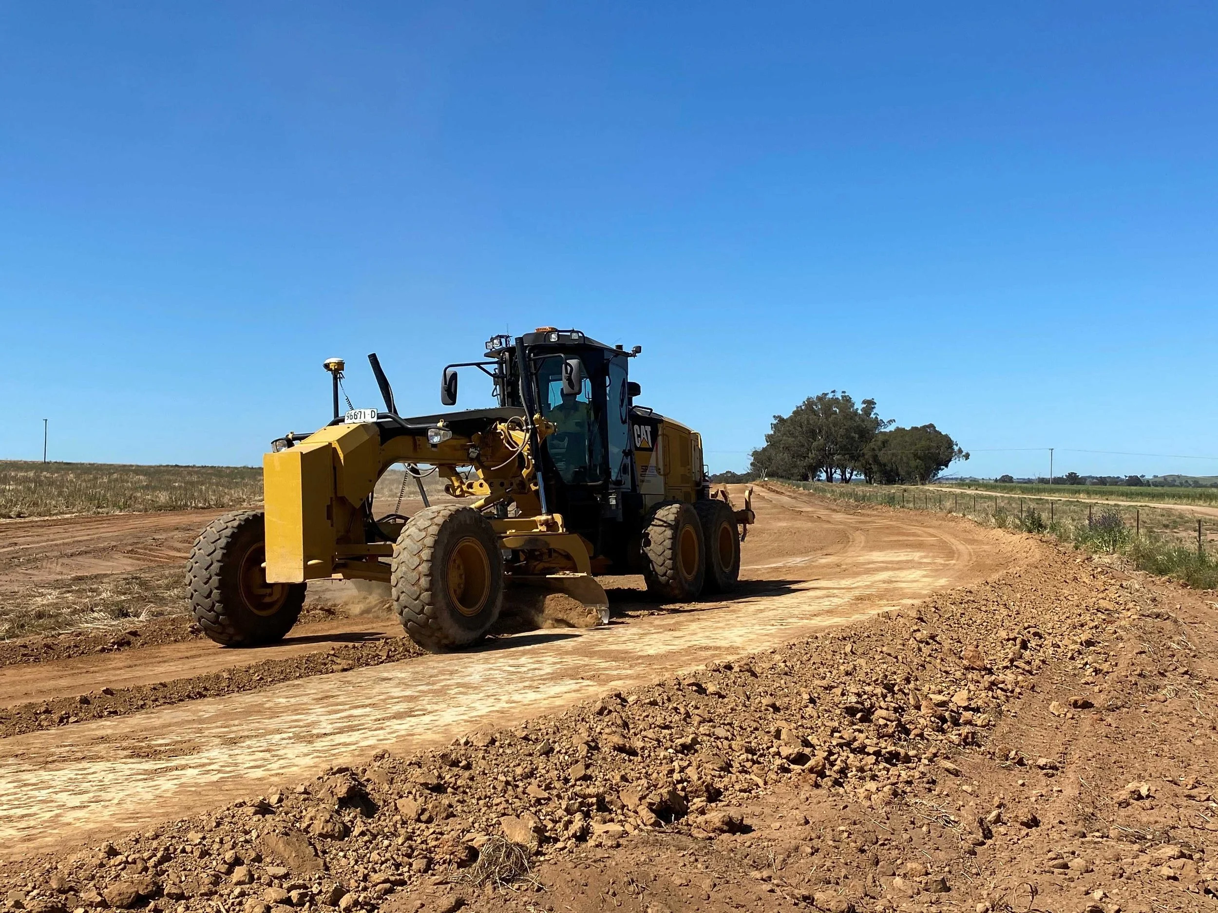 Grader constructing access road for farm infrastructure project, supporting rural earthworks and civil construction works.