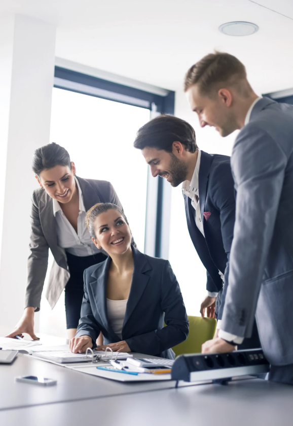 Quattro persone d'affari sorridenti in riunione di lavoro in ufficio moderno