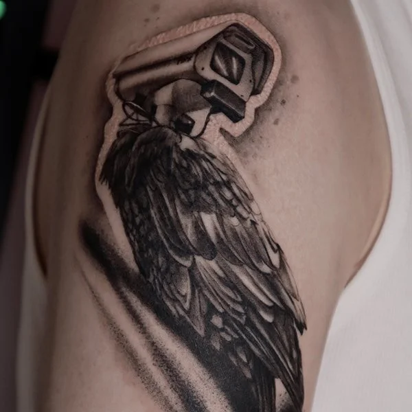 tatovering-surrealisme-arm-fugl-med-kamera-hode.jpg