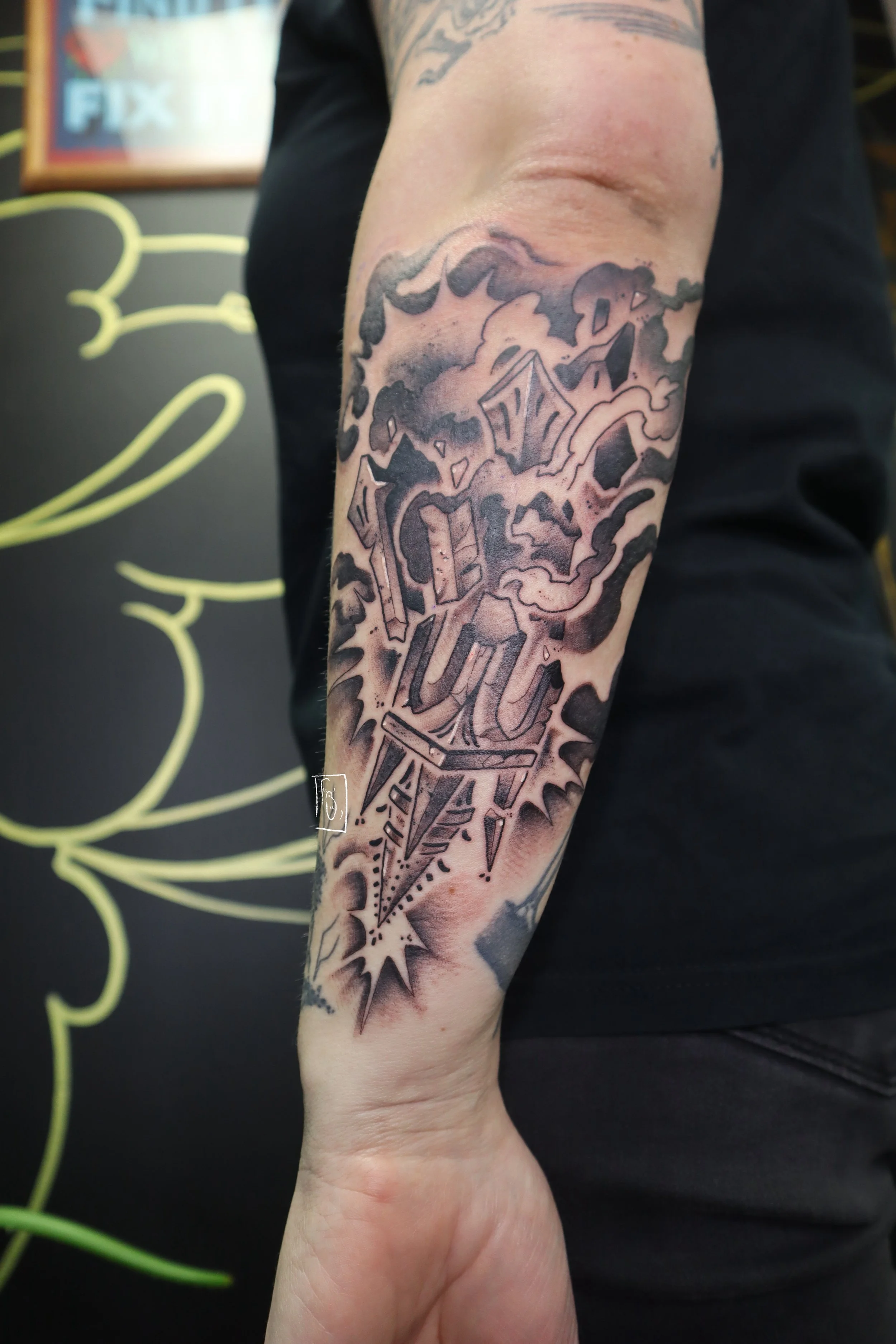 tattoo of a dynamic stormy scene, the top of a tower falls down into an abyss. it is an interpretation of the sixteenth tarot card, the tower, reversed. it is on the outside of a forearm