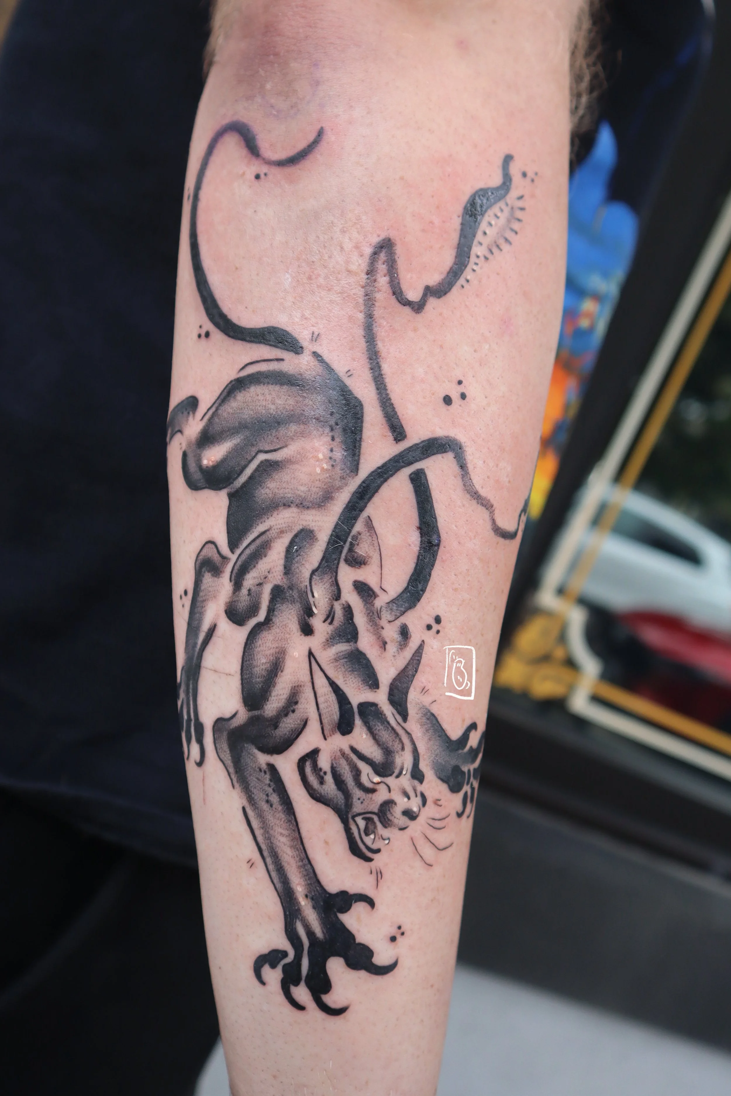 tattoo of a displacer beast from dnd, it is a panther-like creature with six legs and two whip-like tentacles from its back. it leaps with aggression. it is on the client's outer forearm