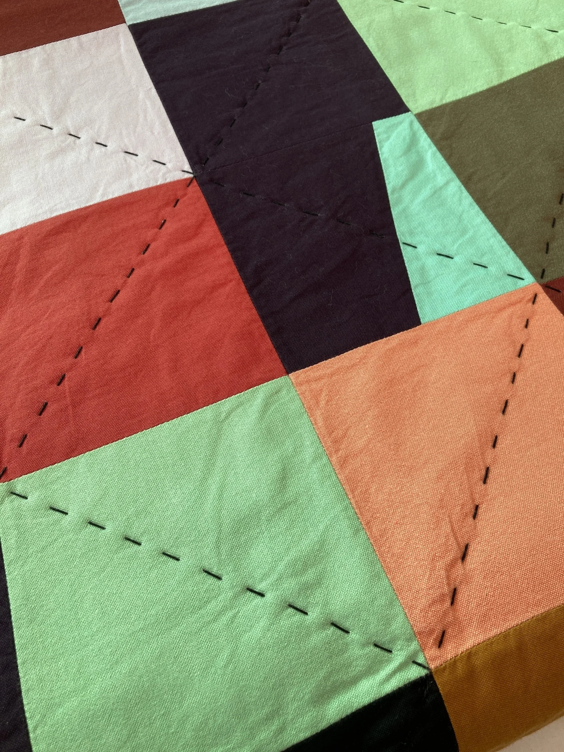 A detail of Hex a hand stitched Blunt Objects patchwork quilt by designer maker Carolyn Thompson
