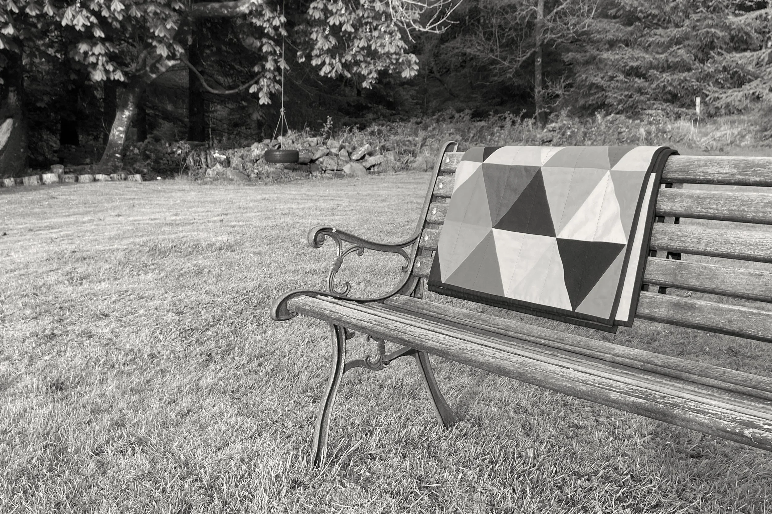 A black and white photography of Jest, an abstract patchwork quilt designed and handstitched by artist Carolyn Thompson for Blunt Objects