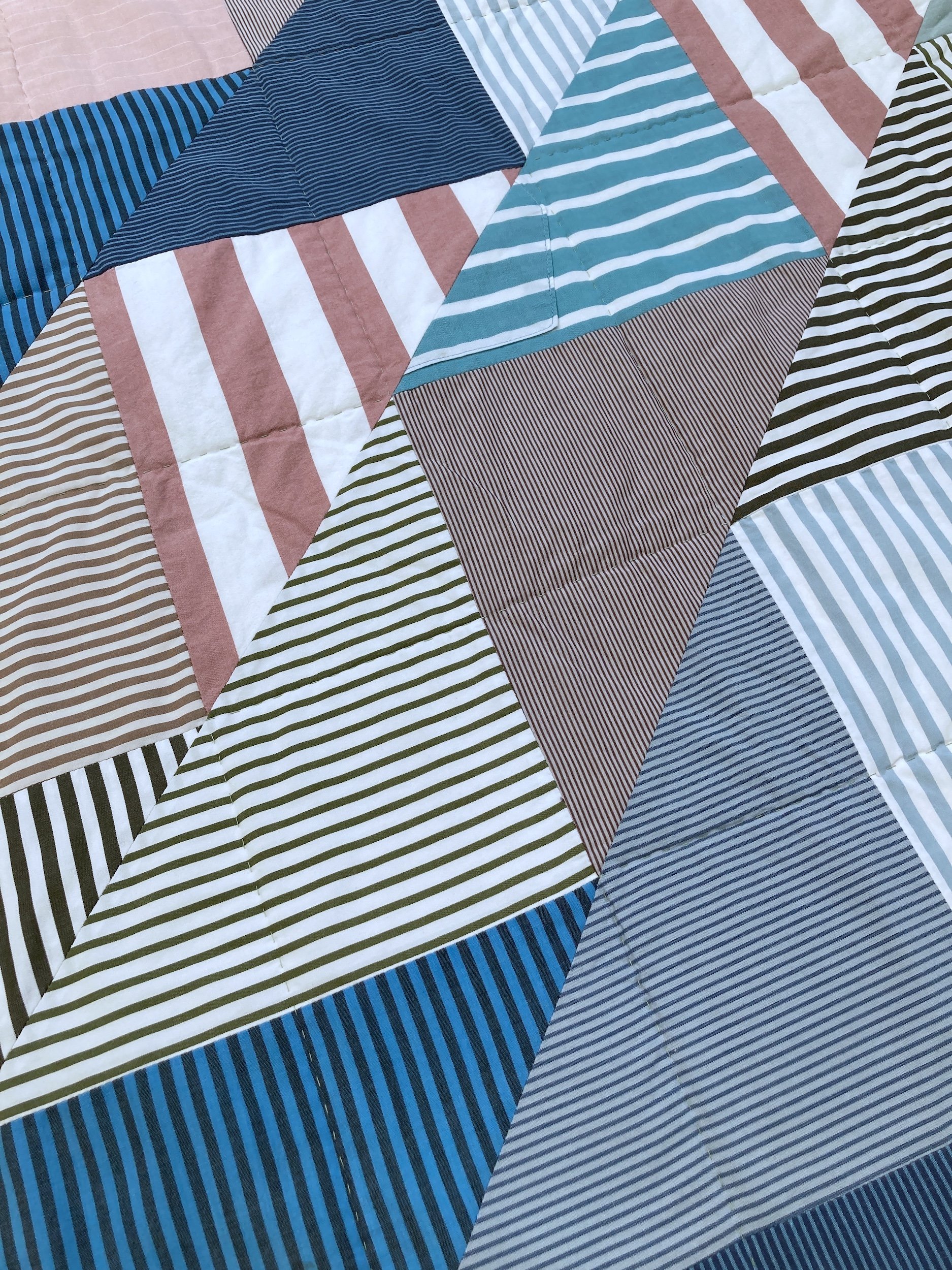 A detail of Punch, a hand stitched Blunt Objects patchwork quilt by designer maker Carolyn Thompson