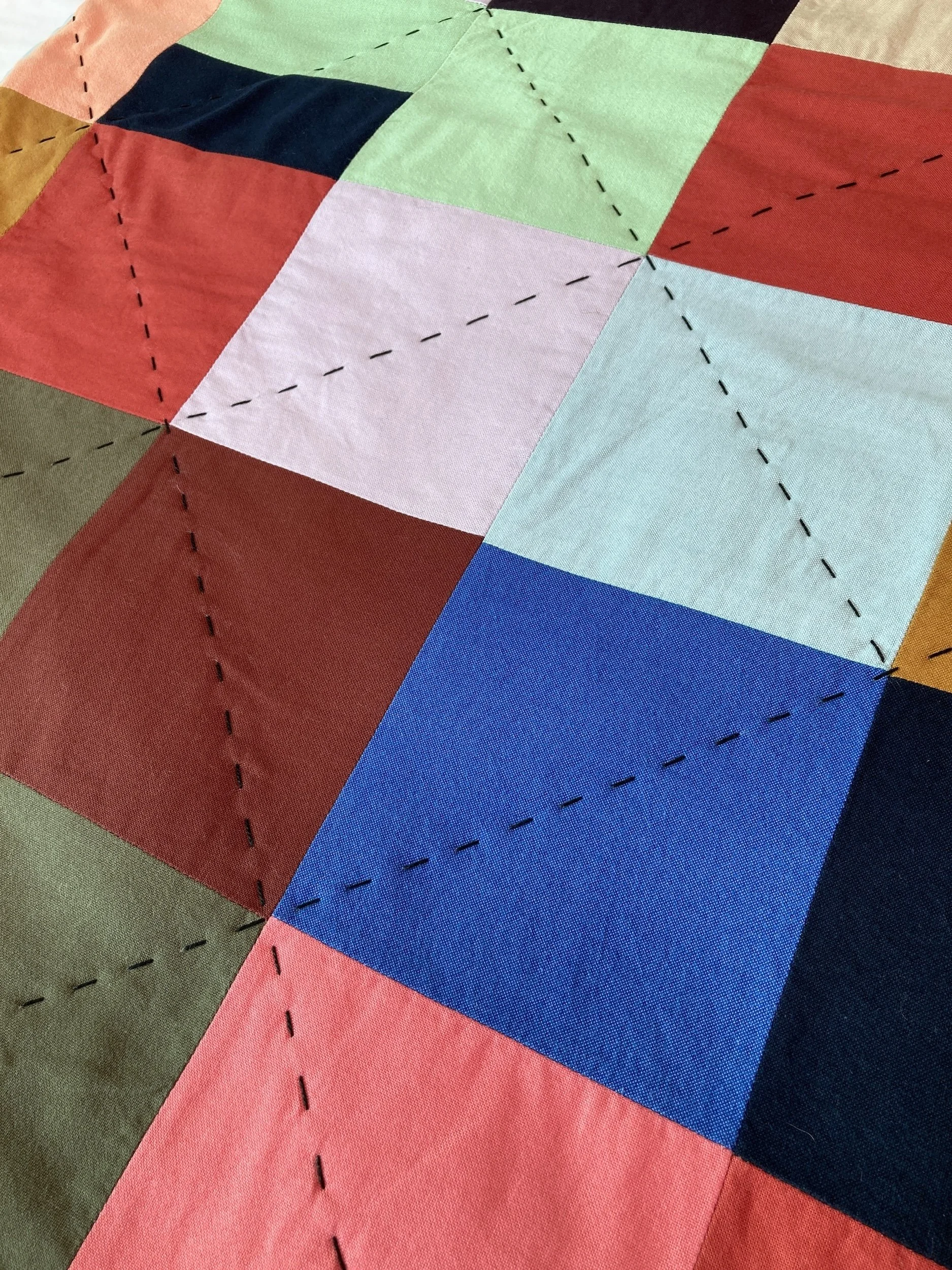 A detail of Hex a hand stitched Blunt Objects patchwork quilt by designer maker Carolyn Thompson