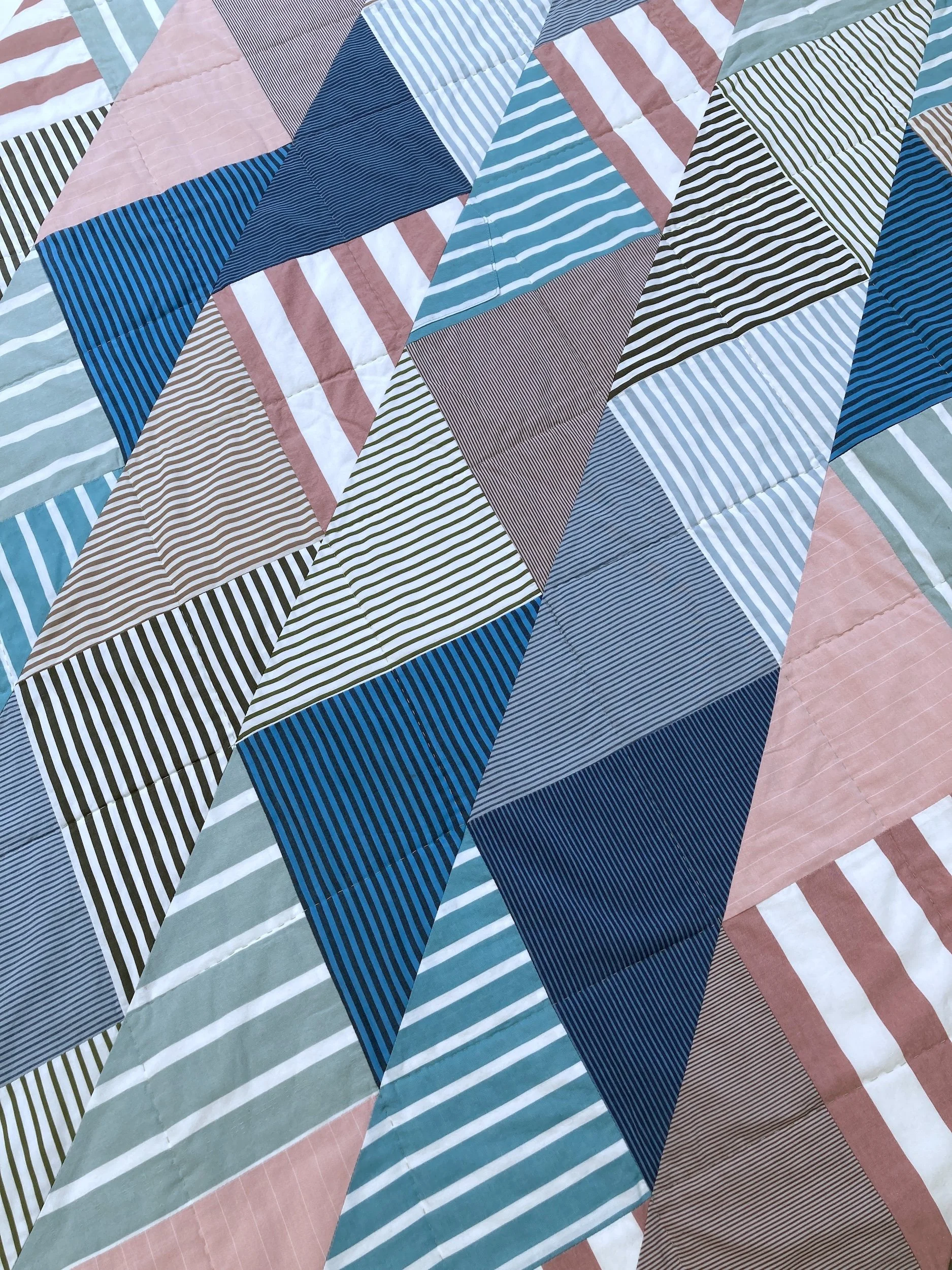 A detail of Punch, a hand stitched Blunt Objects patchwork quilt by designer maker Carolyn Thompson