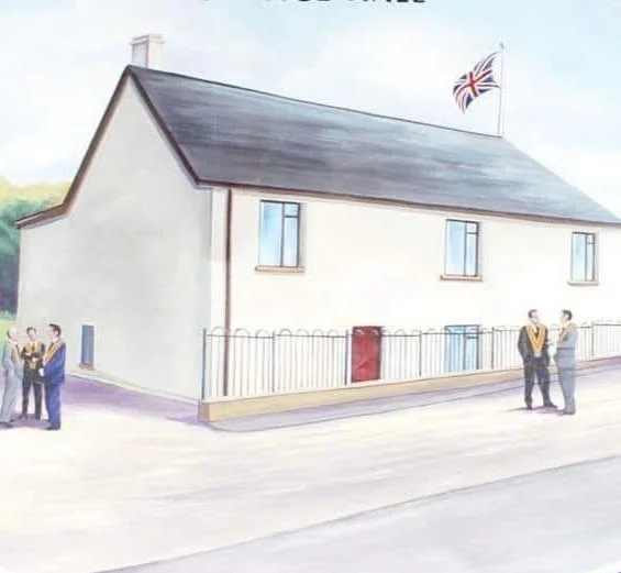 A white building with a dark roof, a British flag flying on top, and a fence around it. Four people stand outside, talking in pairs.