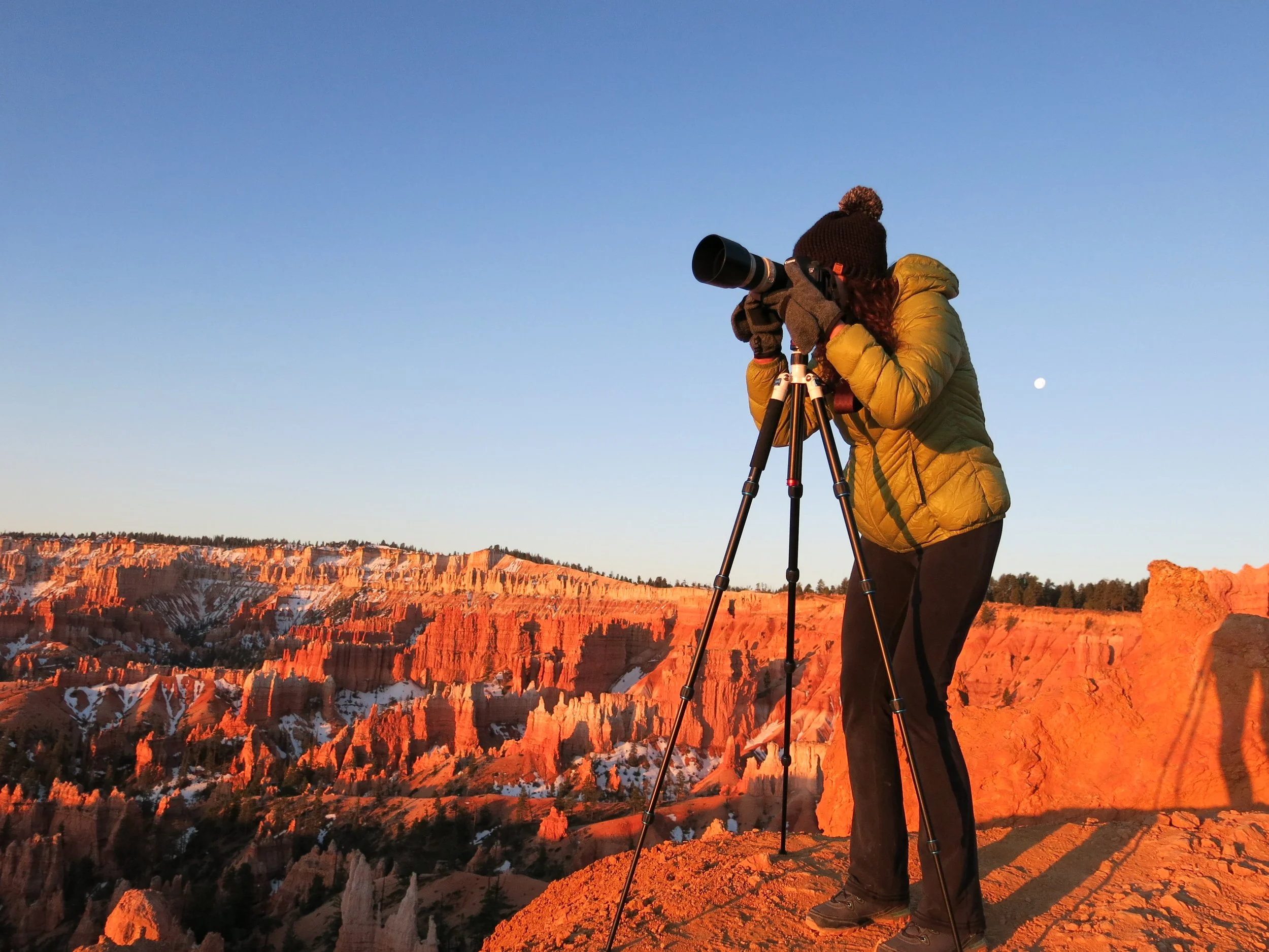 Photographer Katie Dobies looking through the lens at Bryce Canyon National Park
