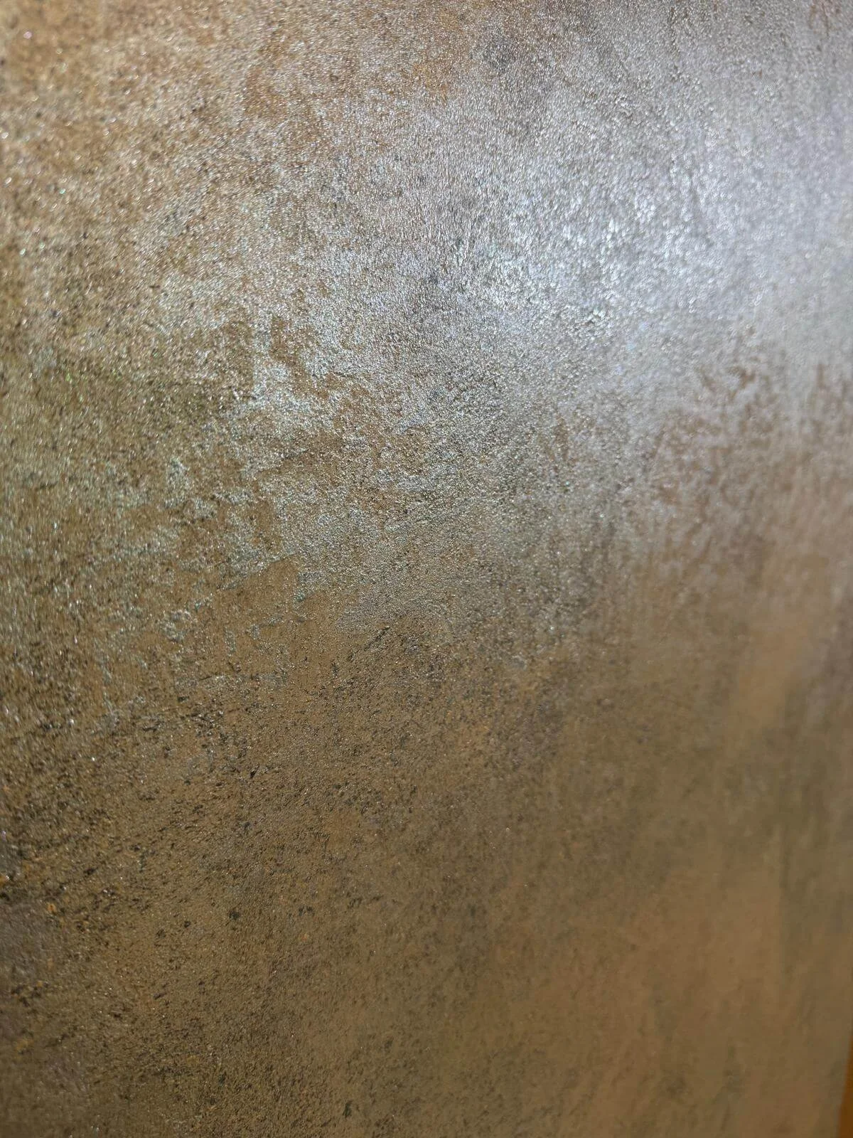 Close-up of a textured, metallic surface with a gold or bronze finish.