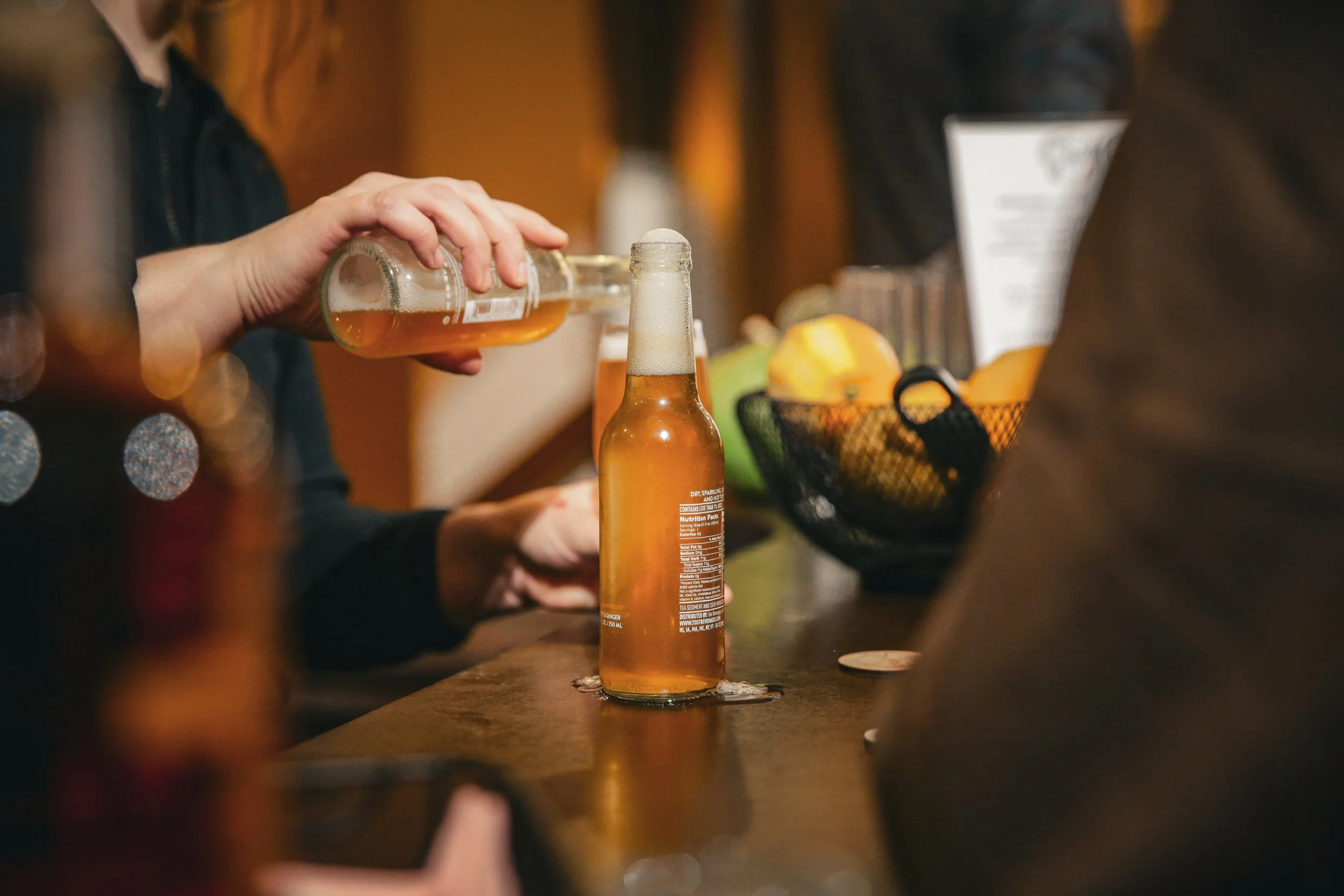 A bartender pouring a beverage at the open bar during a Story Feast event at a monastery dinner