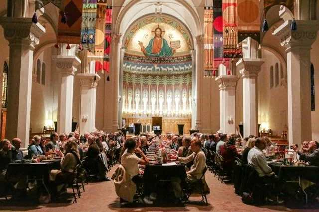 Guests gathered at candlelit monastery dinner table for Story Feast experiential dining event