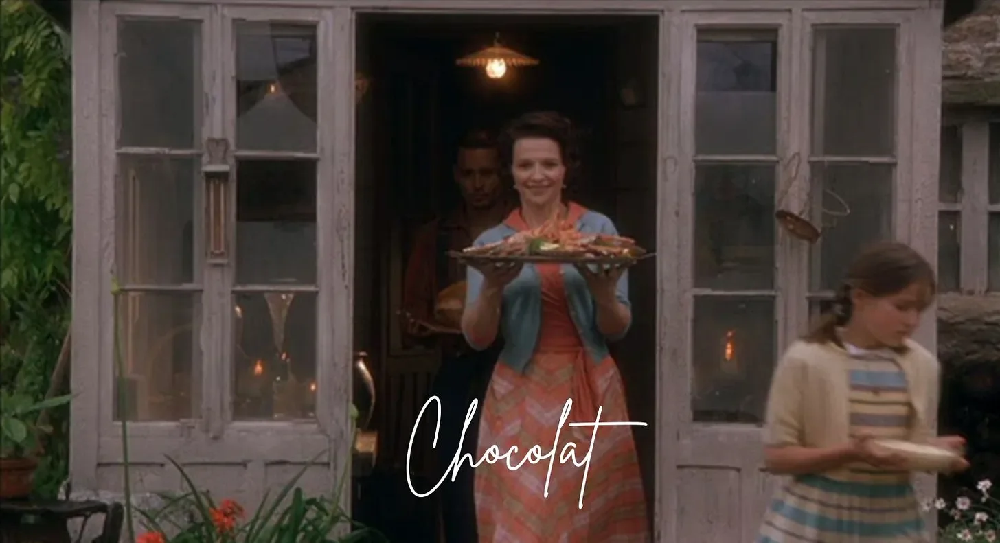 The outdoor dinner party scene from the movie Chocolat, with guests seated at a candlelit table along the river