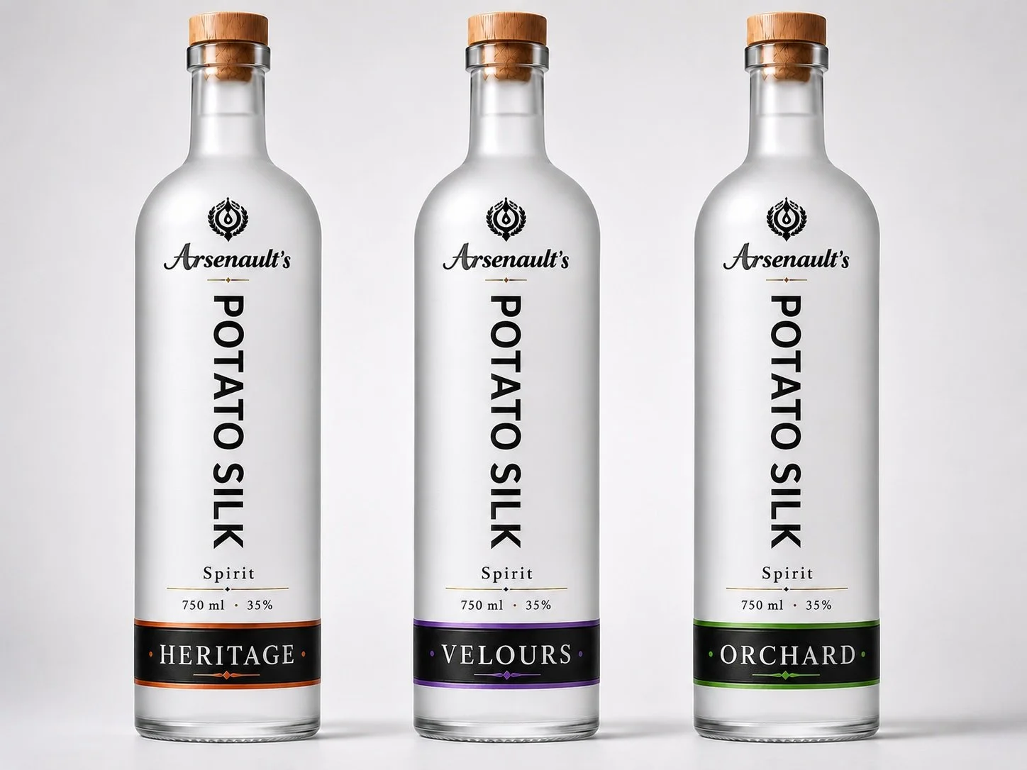 Three bottles of Arsenault's Potato Silk Spirit, each with a wooden cap and labeled as Heritage, Velours, and Orchard varieties, standing side by side against a plain background.