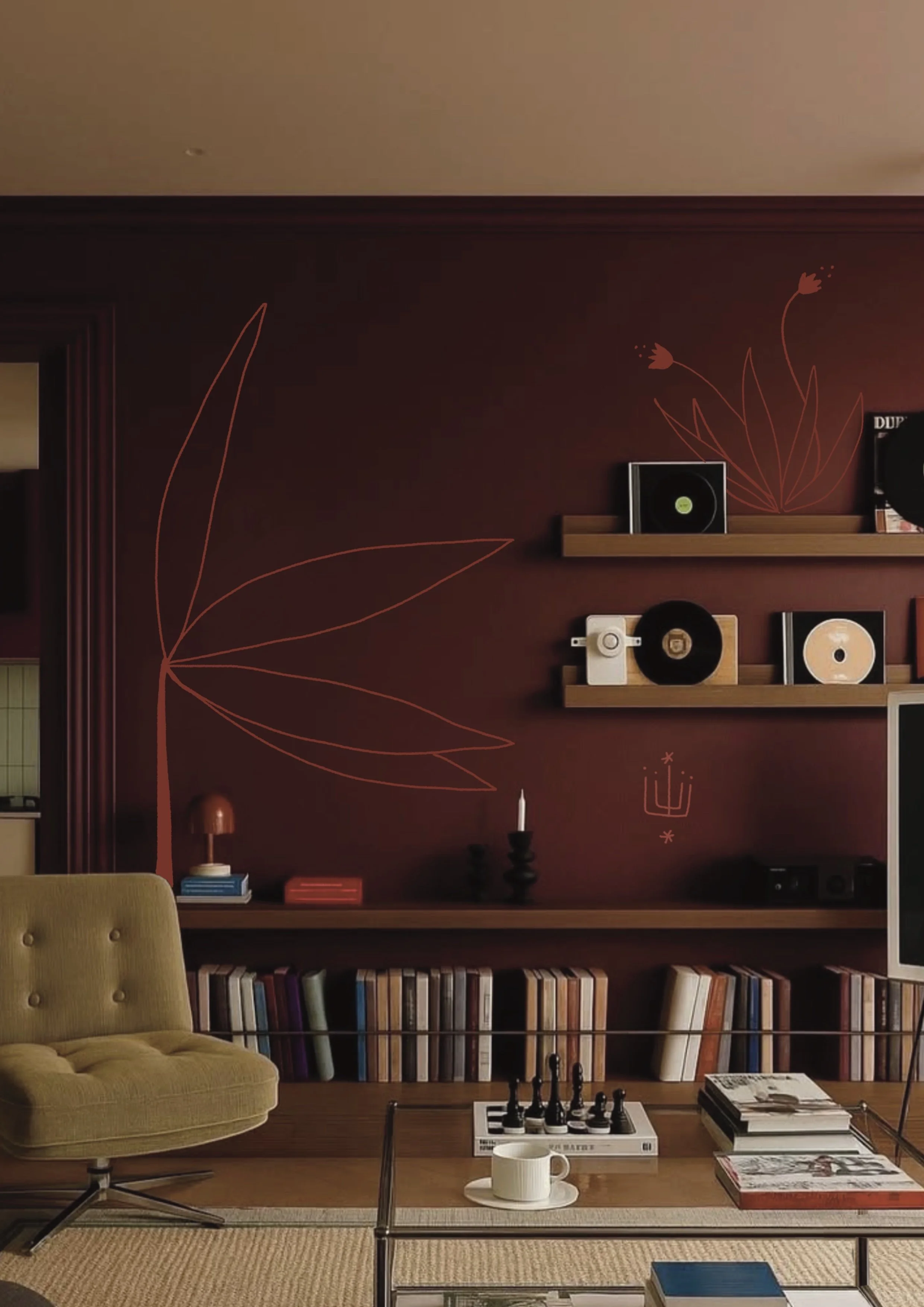 A cozy living room with a dark red wall decorated with minimalist line art of flowers. There are two floating shelves holding vinyl records and a small speaker. A mustard yellow lounge chair is in the foreground, next to a coffee table with a chess s
