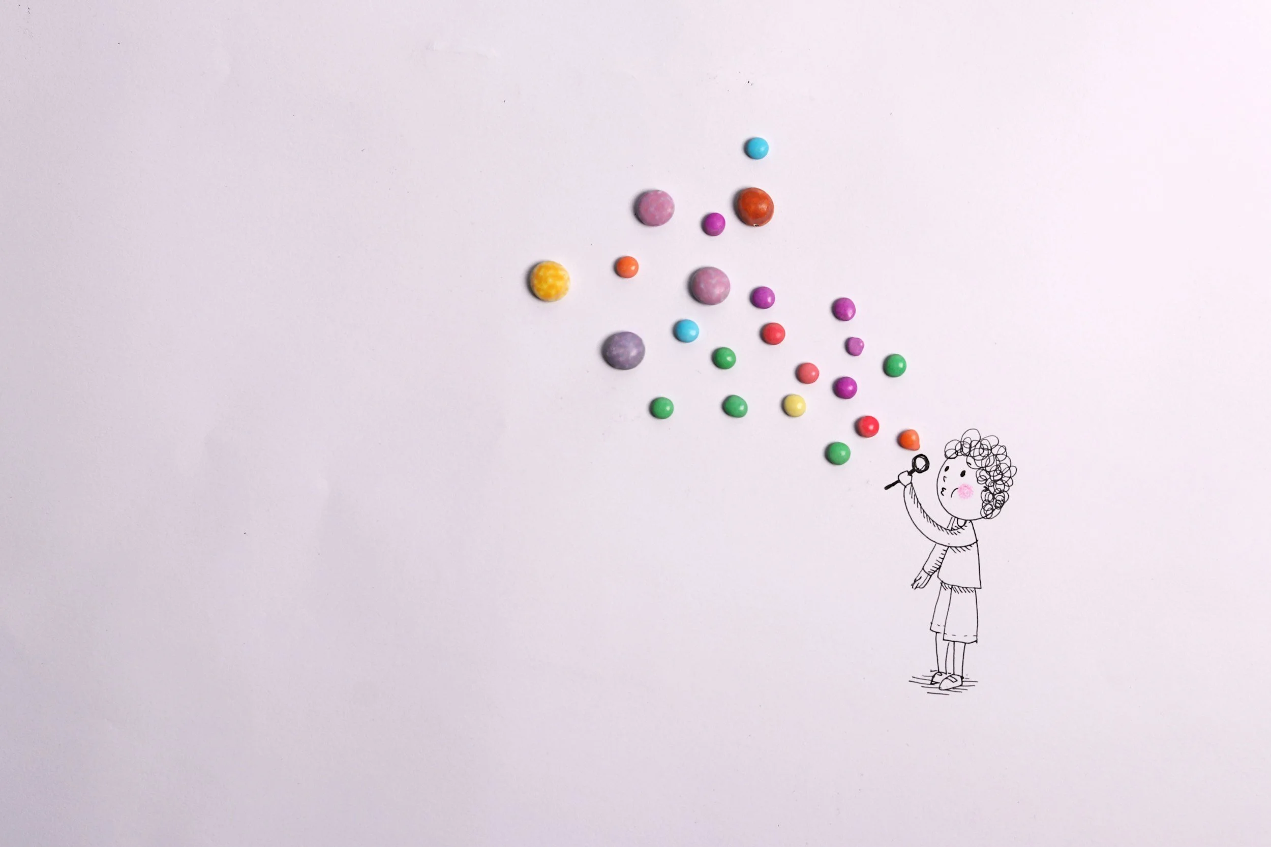 pen-drawn person blowing bubbles made of paint