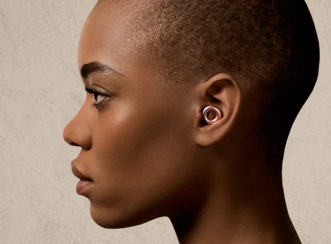 Side profile of a woman wearing loop earplugs.