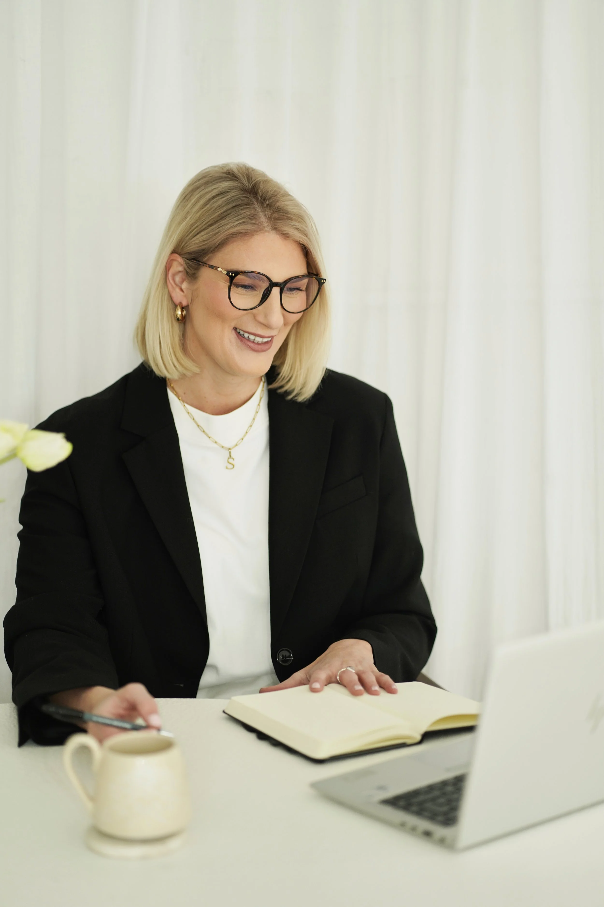 Sarah E Mold Professional career coach in black blazer on Zoom call with client, smiling