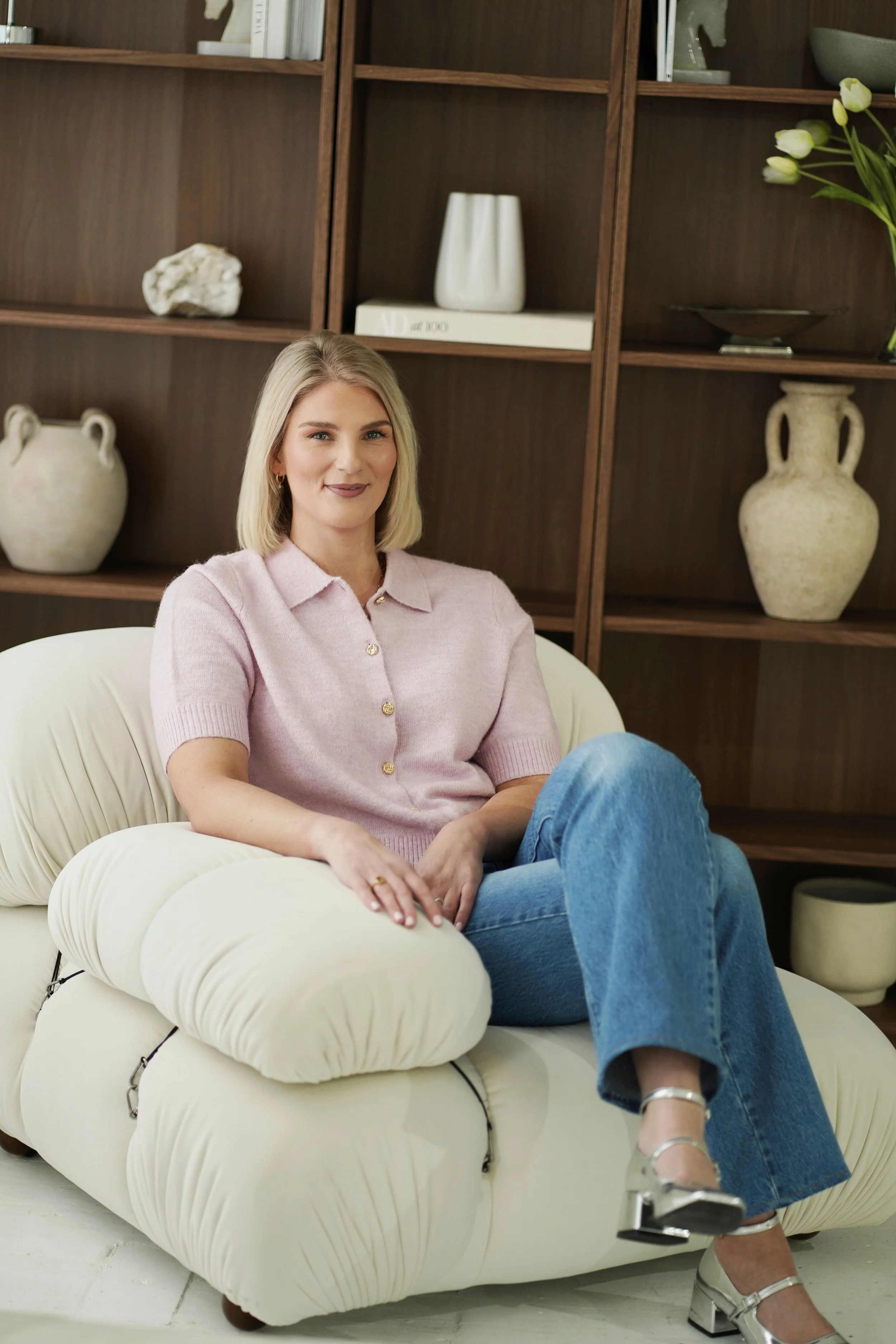 Sarah E Mold leadership coated, seated in armchair in modern office space