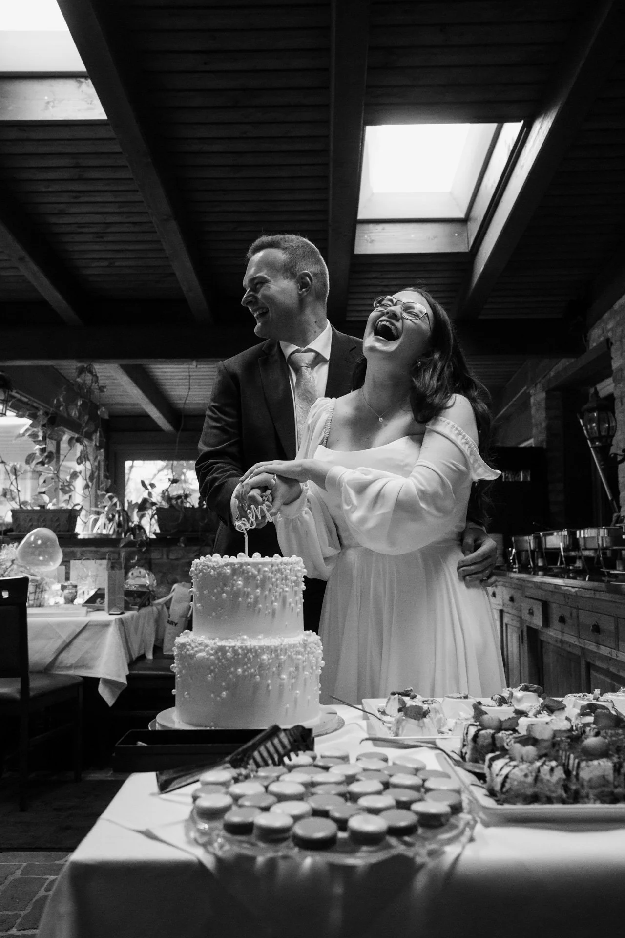 Brautpaar schneidet Torte an voller Lachen