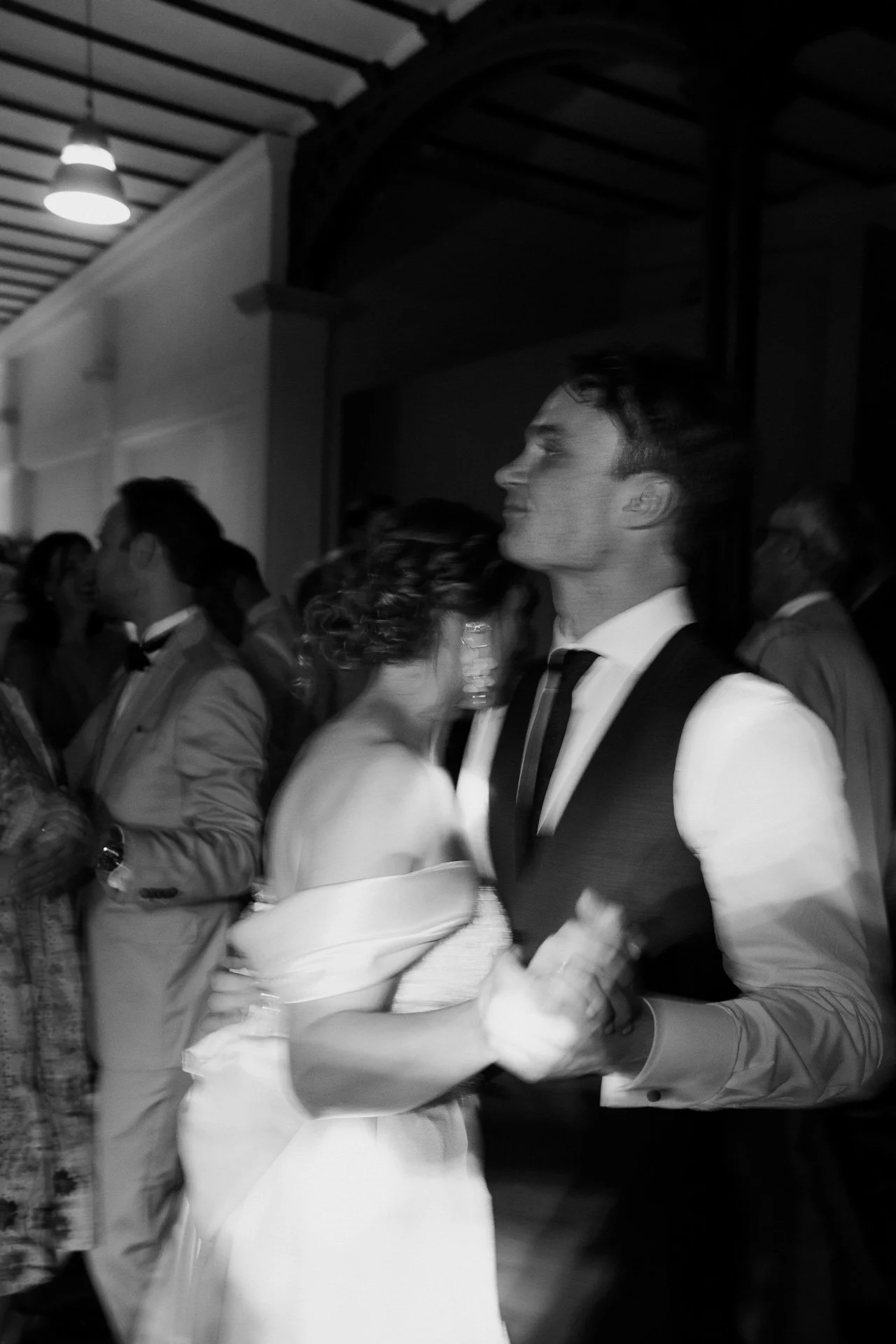 Ein Brautpaar tanzt auf einer Hochzeit, umgeben von Gästen.