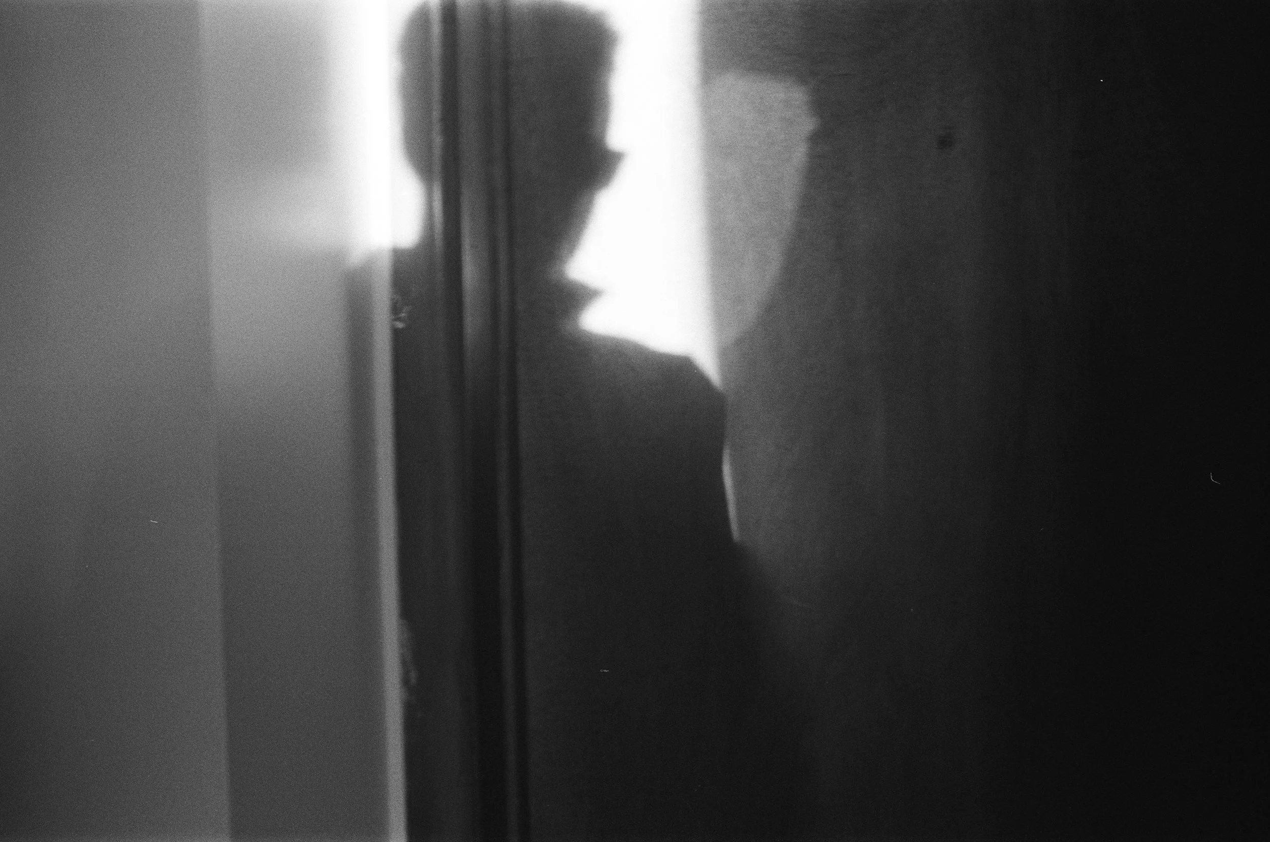 A black and white photo of a man's shadow against a wall.