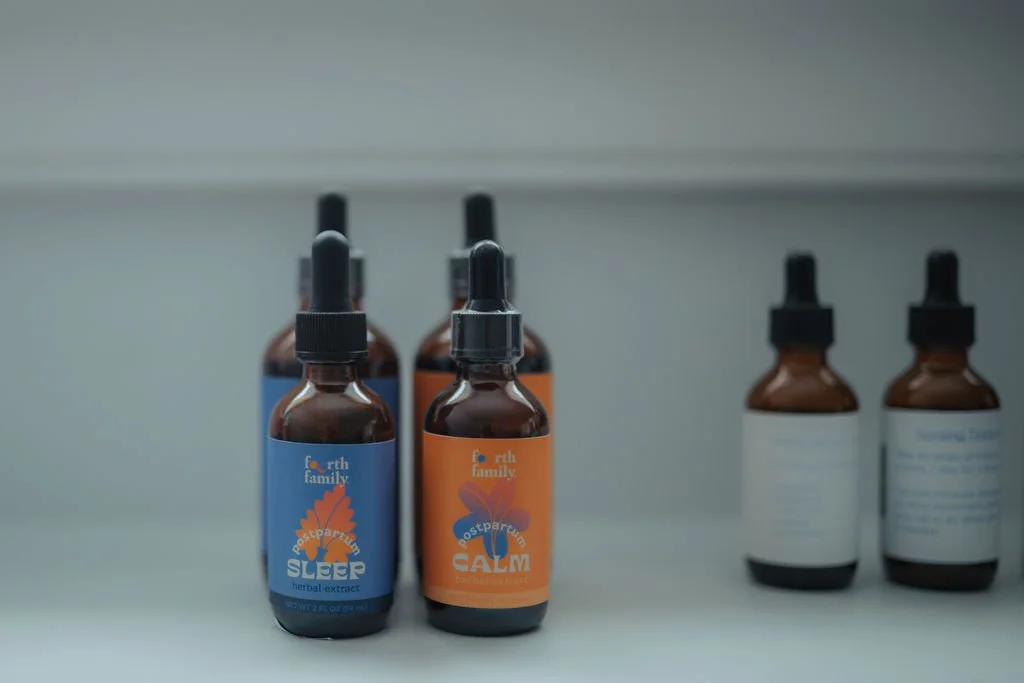 Brown glass bottles with dropper caps on a shelf, labeled with herbal extracts for sleep and calm from North Family.
