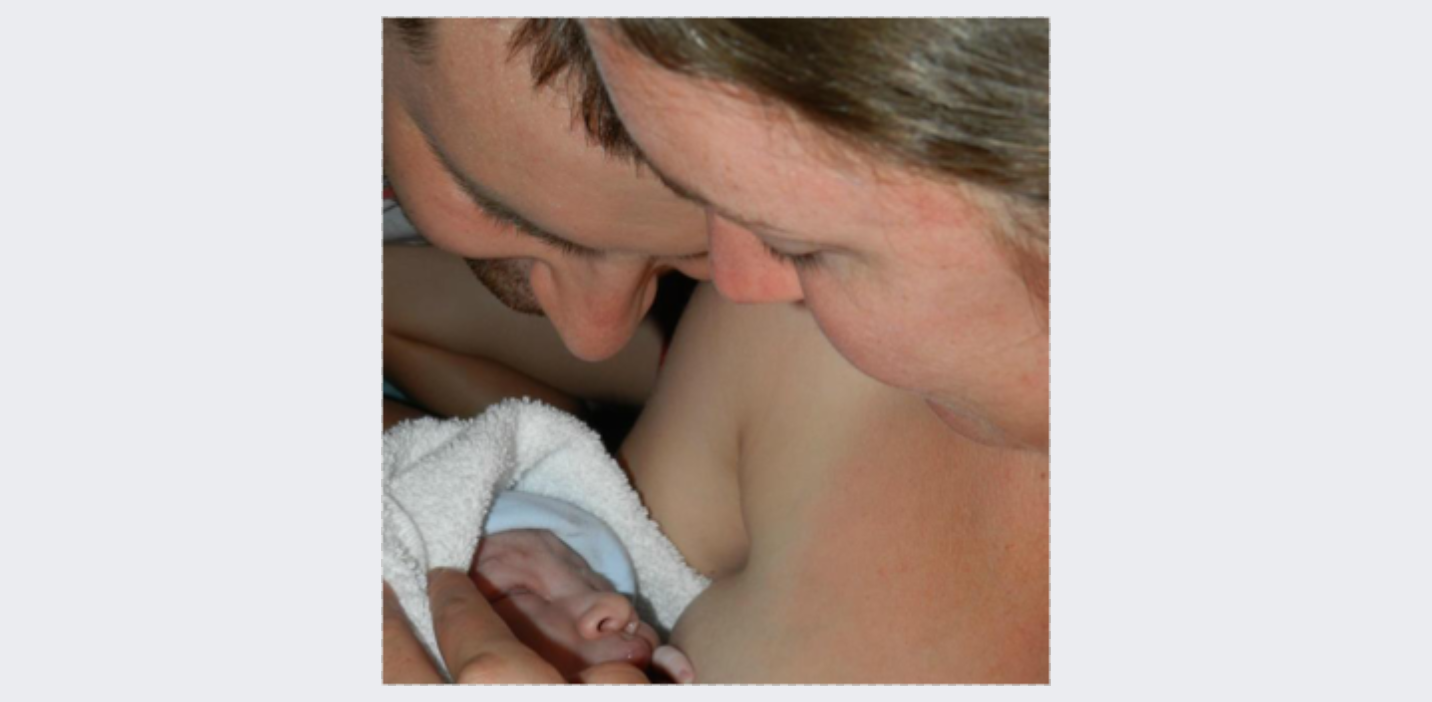A man and a woman holding a newborn baby close to their faces, with the baby wearing a hat and wrapped in a blanket.