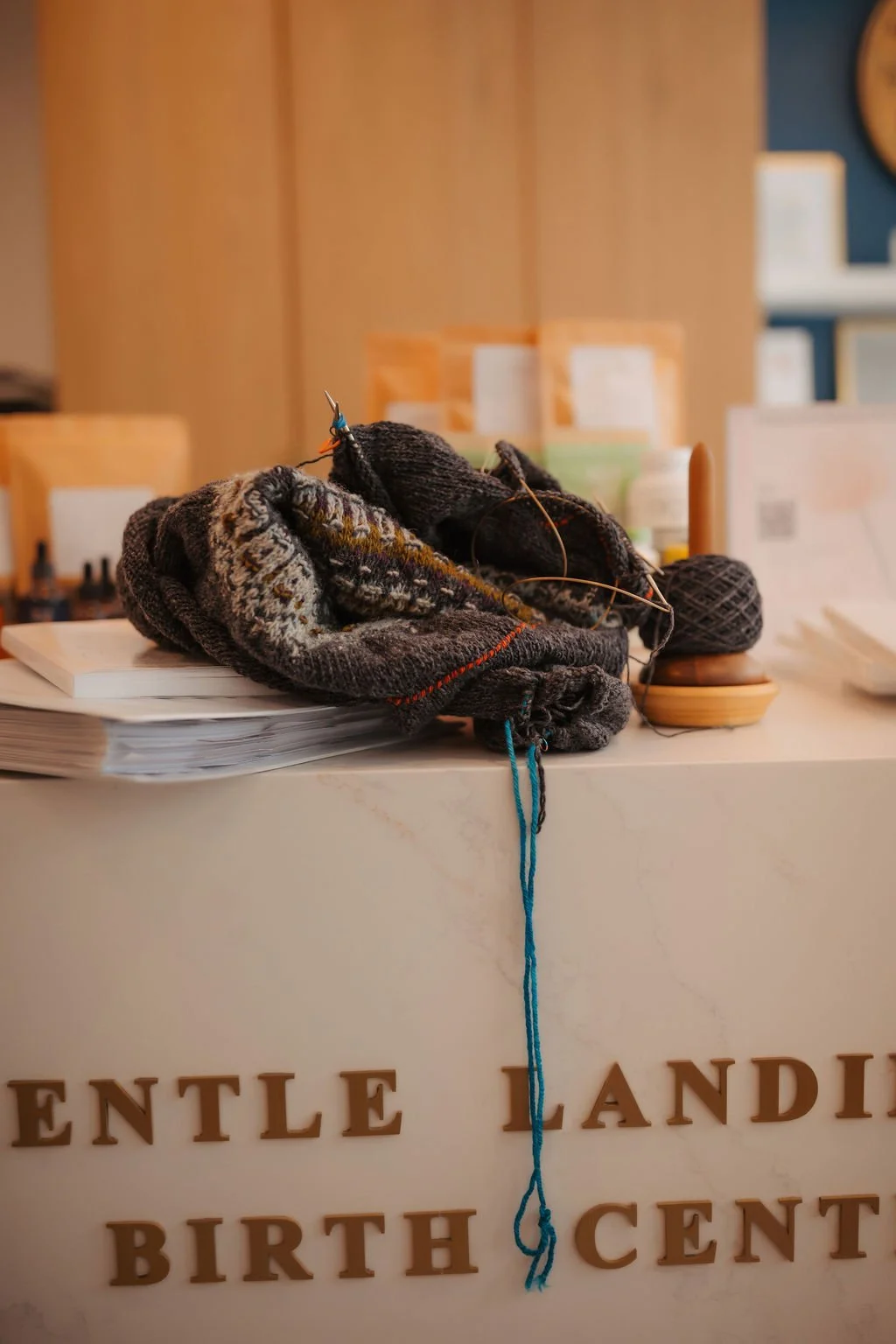 A pile of knitting projects, yarn, and knitting needles on a counter at a birth center.