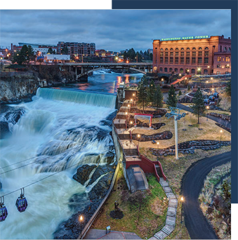 Cityscape with waterfalls, a bridge, and a park at dusk