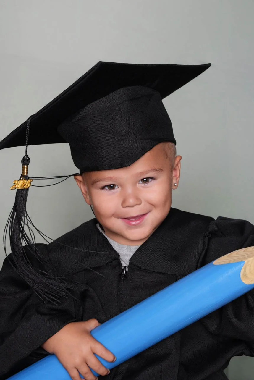a-young-boy-in-a-graduation-gown-holding-a-diploma-5.jpg