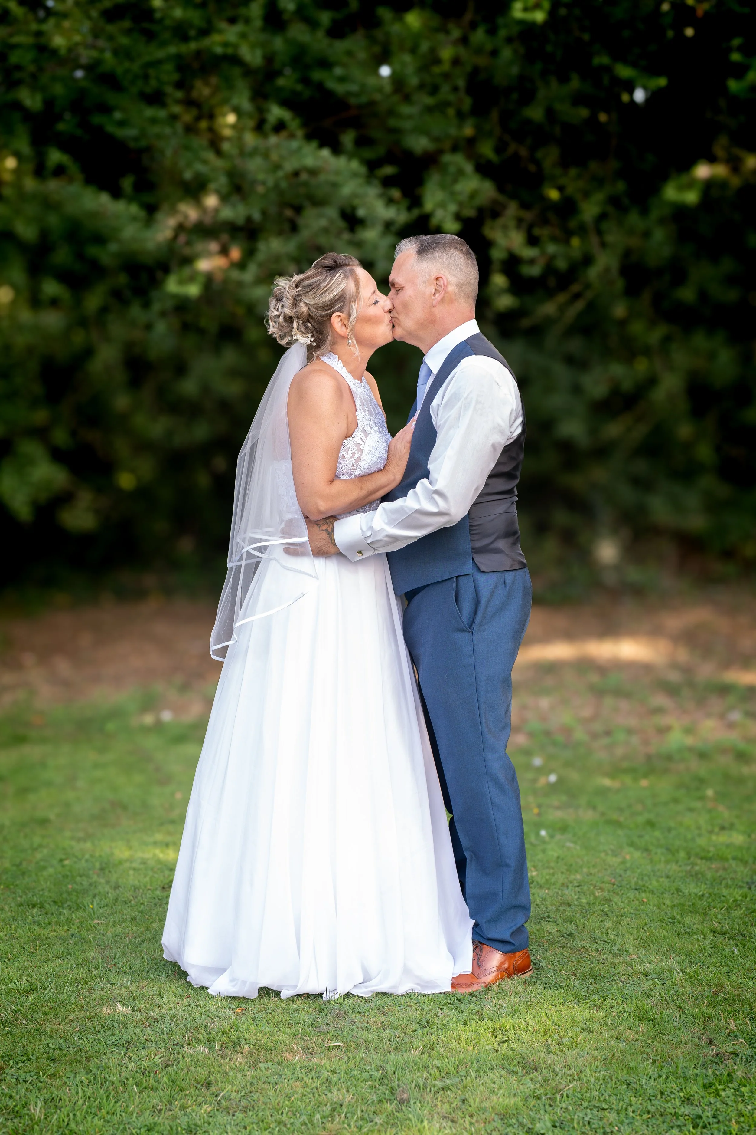 a-bride-and-groom-kissing-in-the-grass.jpg