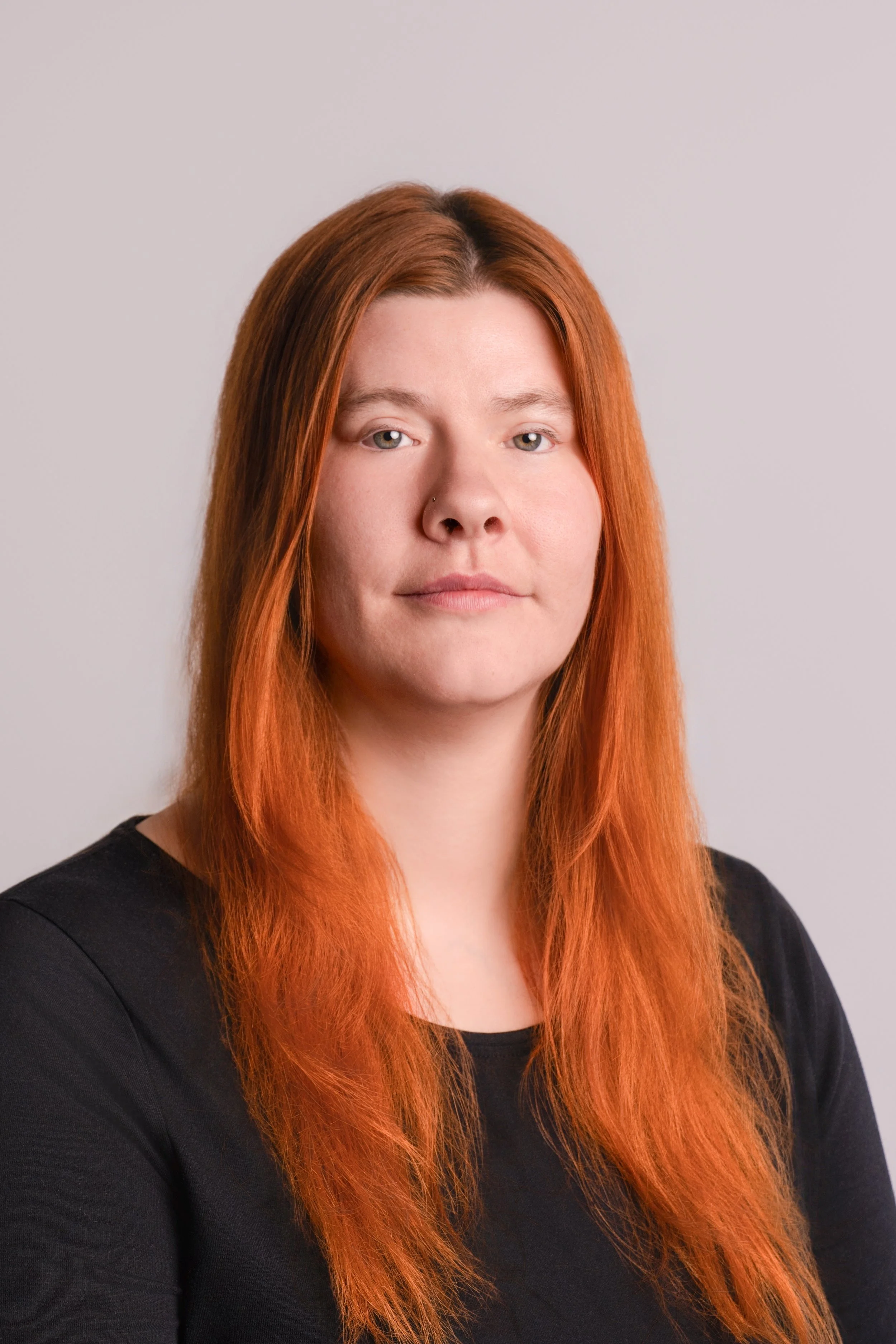 Professional headshot of creative business owner with natural light background
