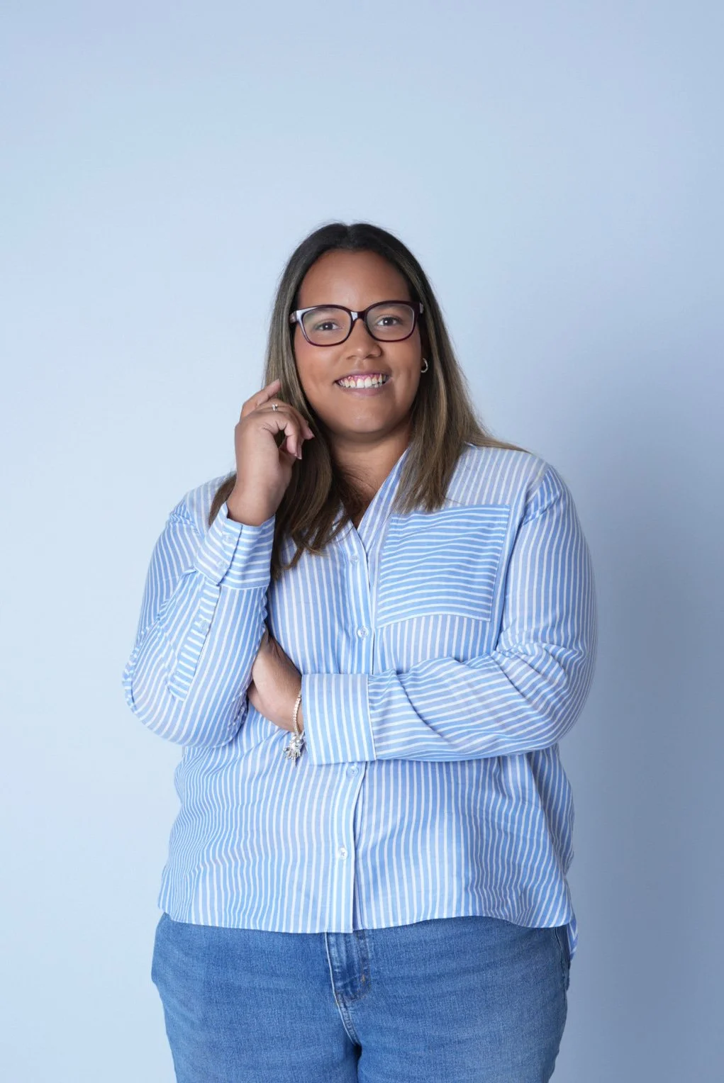 A group of young women performing a dance routine on stage, with some wearing black crop tops and shorts, and others wearing plaid shirts tied around their waists, under stage lighting with a large backdrop reading 'POPS DALLS'.