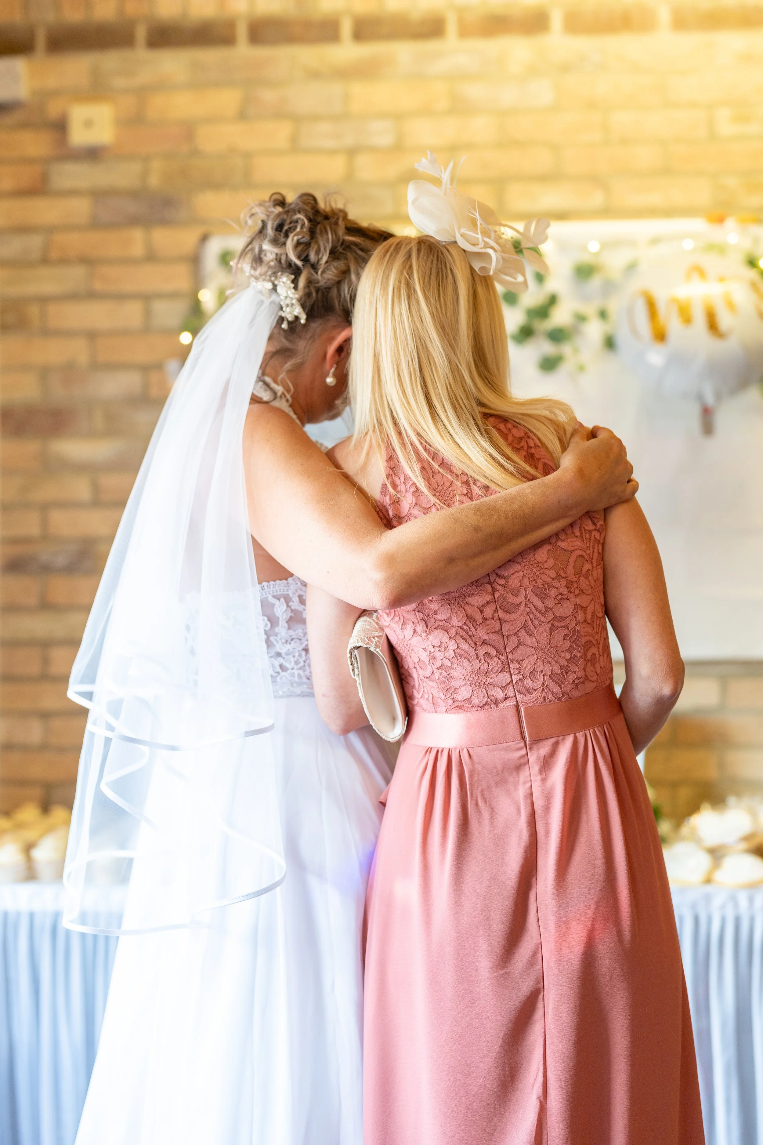 a-bride-and-her-mother-hug-at-the-end-of-the-wedding-ceremony.jpg