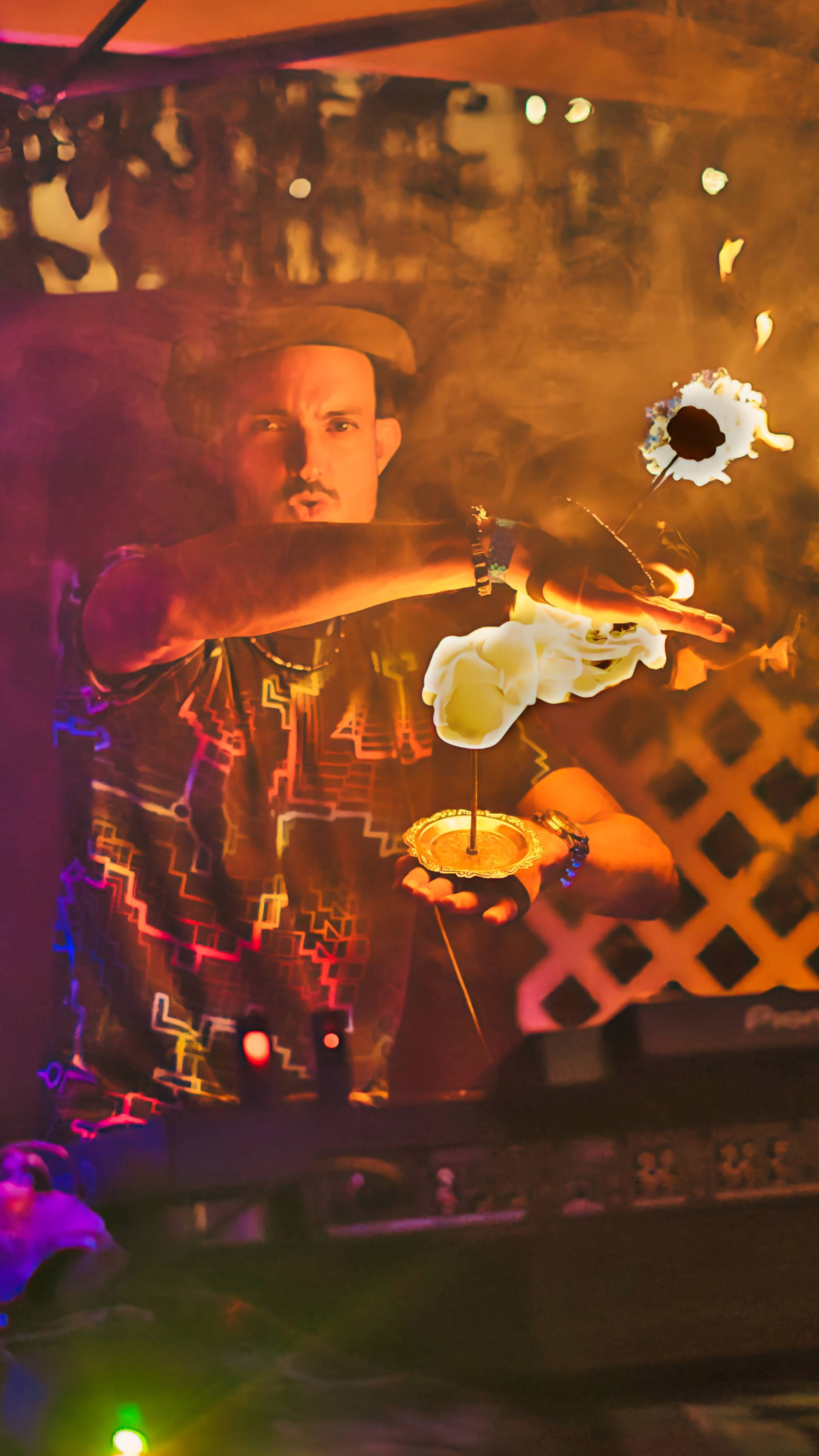 Person performing a fire dance with flaming props at night.