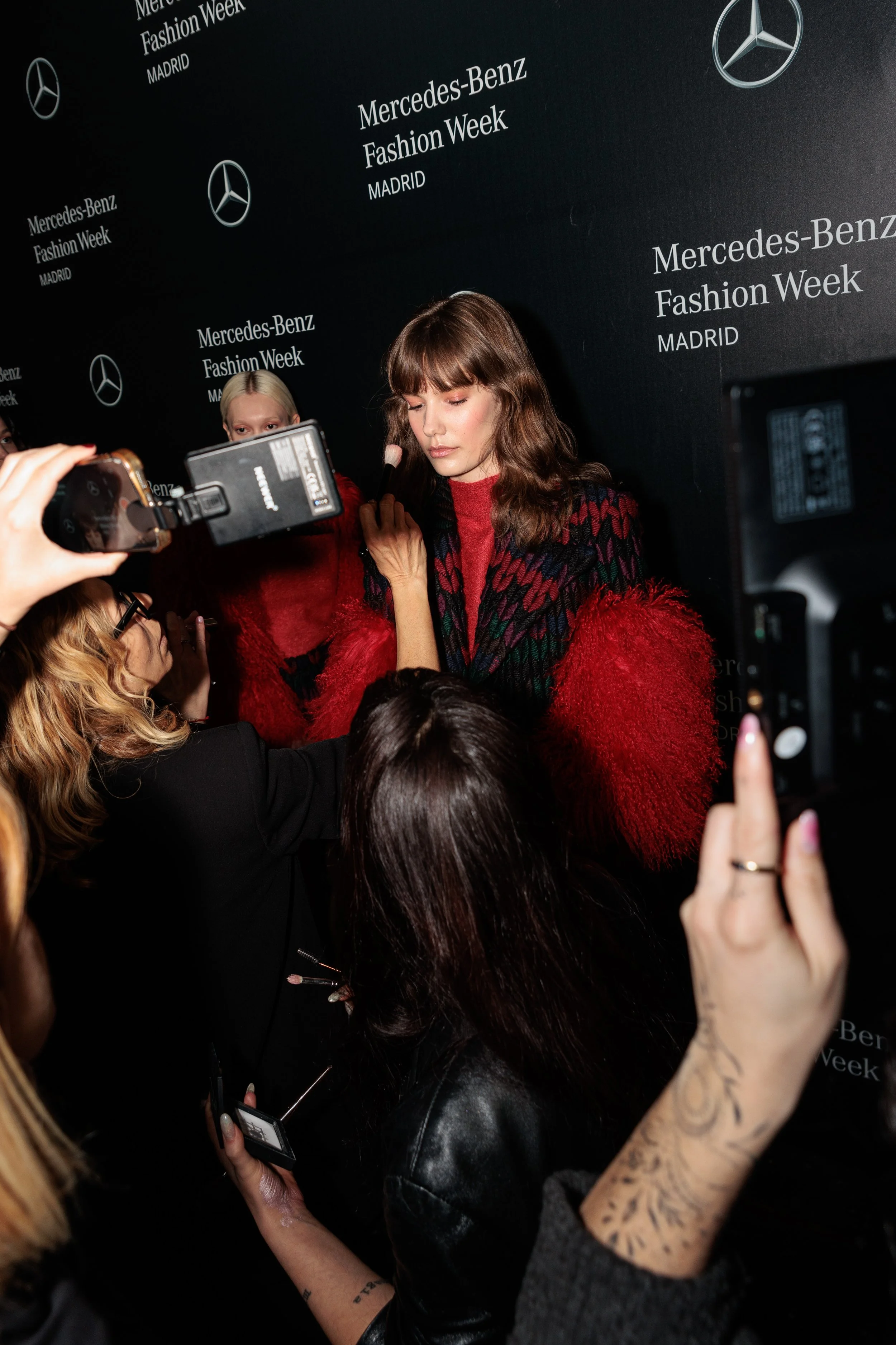 Modelo posando en un evento de la Mercedes-Benz Fashion Week en Madrid, rodeada de periodistas y fotógrafos.