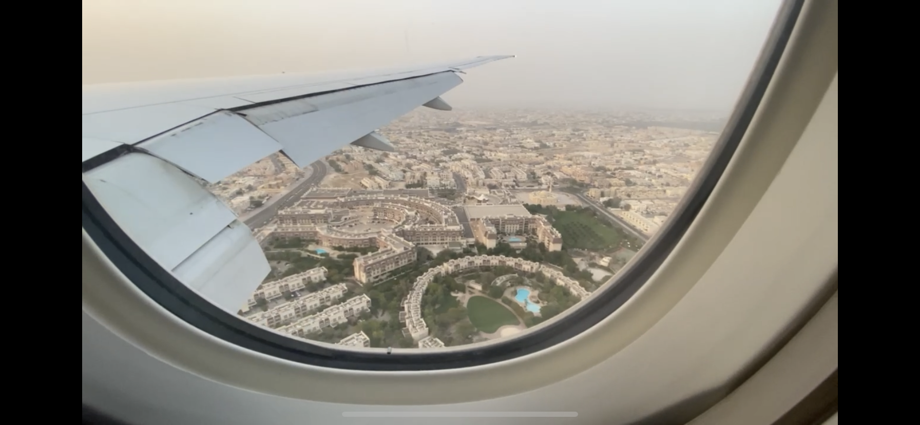 View of urban landscape and buildings seen through airplane window.