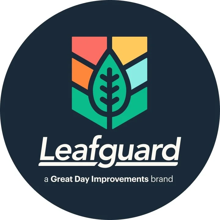 A circular logo with a dark background, featuring a colorful leaf and geometric shapes, with the text 'Leafguard' and 'a Great Day Improvements brand' underneath.