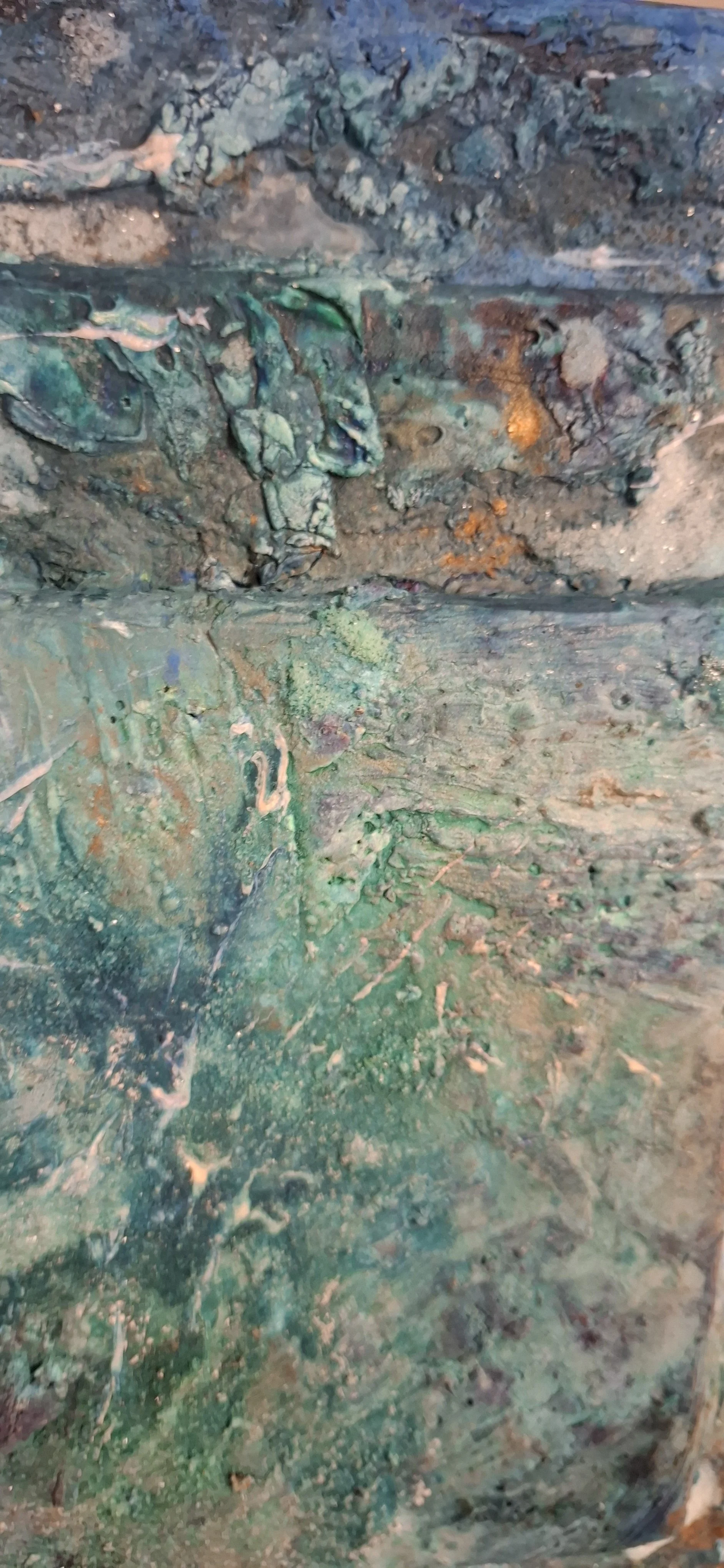 Ein abstraktes, texturiertes Gemälde mit grünen, blauen und erdigen Farbtönen, das dicke Pinselstriche und schichtartige Strukturen zeigt.