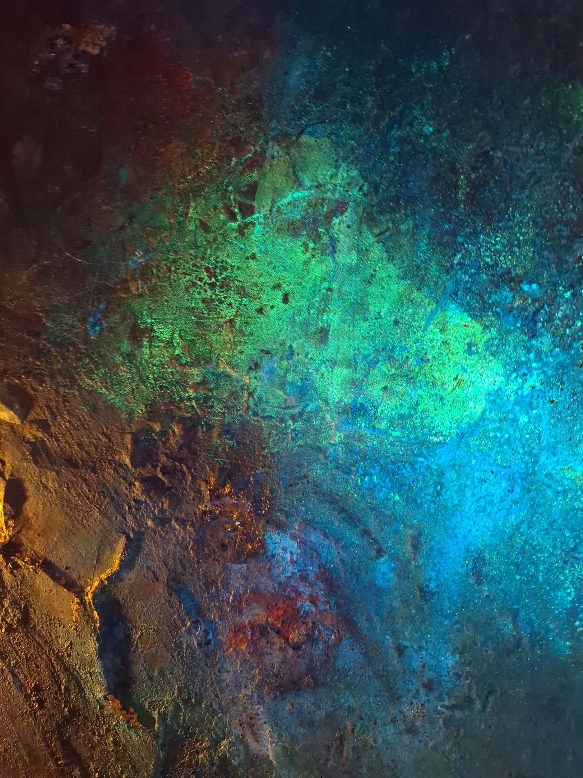 Farbenfrohe, irideszierende Minerale auf einer mineralischen Oberfläche, leuchtende Grün-, Blau-, Rot- und Goldtöne, schimmernd und glänzend