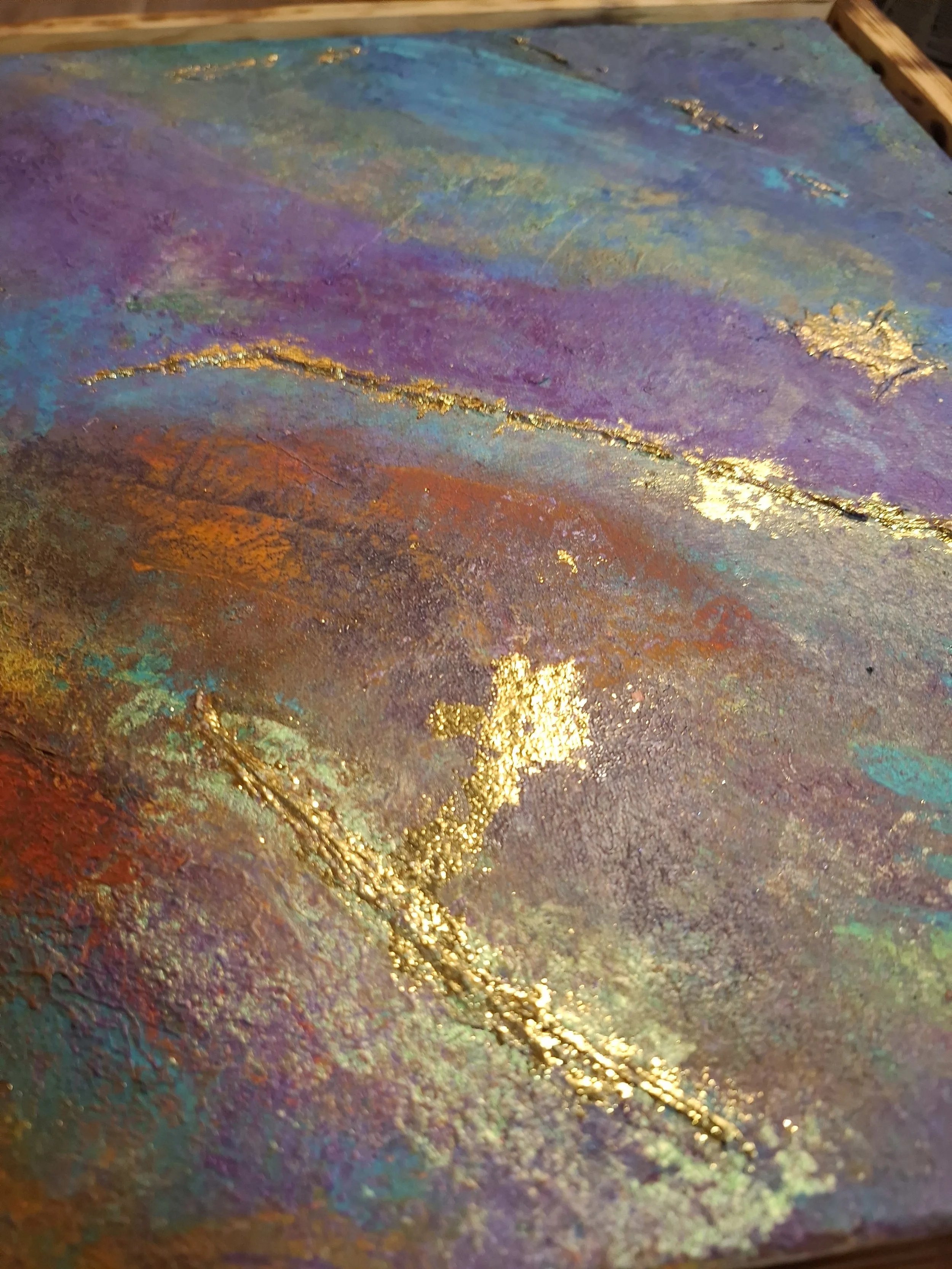 Abstraktes Gemälde mit lebhaften Farben, Goldakzenten und einer Textur, die an eine Landschaft oder Himmel erinnert.