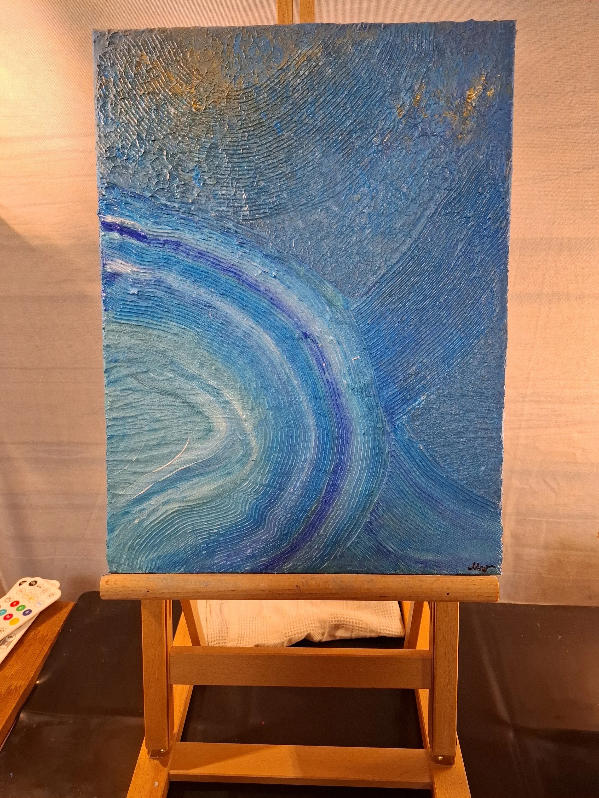 Abstraktes Gemälde mit blauen und goldenen spiralenförmigen Mustern auf Leinwand.