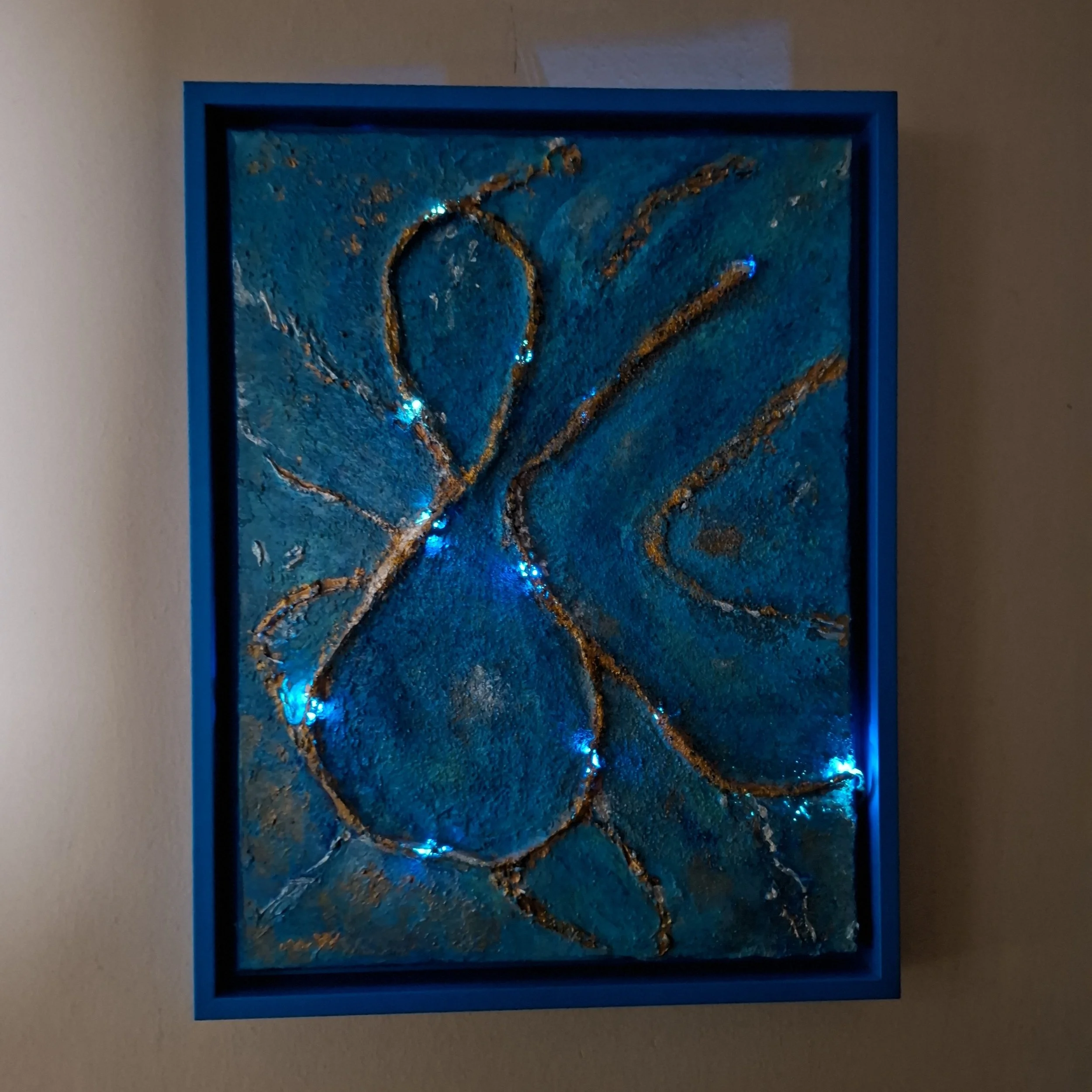 Kunstwerk mit blauer Hintergrundfarbe und goldenen Linien, umrandet von einem blauen Rahmen.