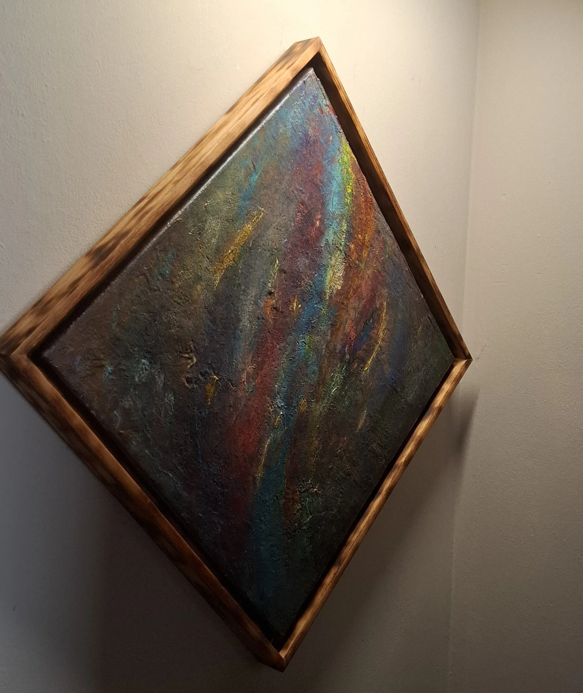 Abstraktes Gemälde in einem Holzrahmen, das auf einer weißen Wand hängt.