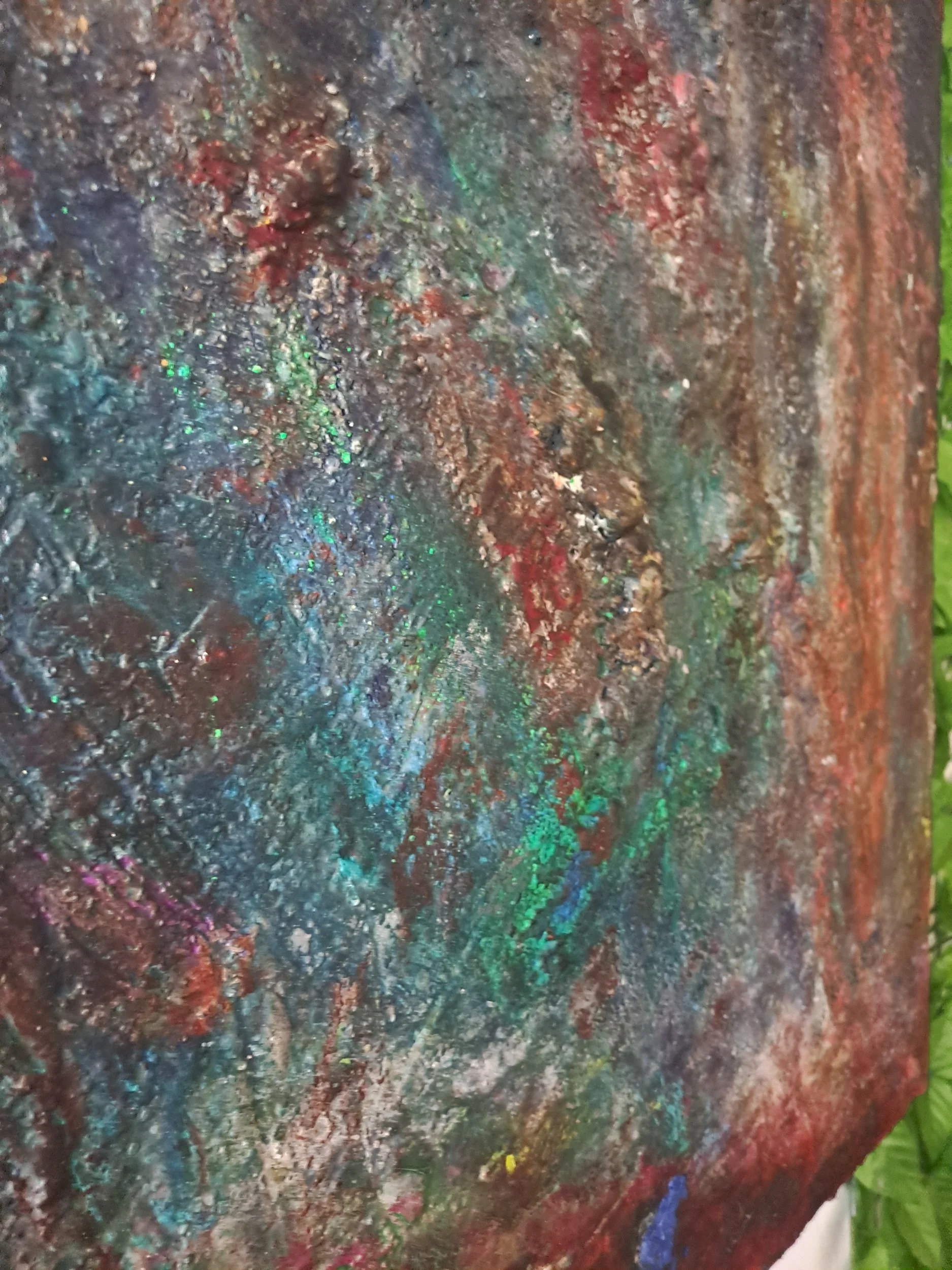 Ein bunter, strukturierter und glitzernder Maluntergrund mit verschiedenen Farbtönen, darunter Blau, Rot, Grün und Silber.