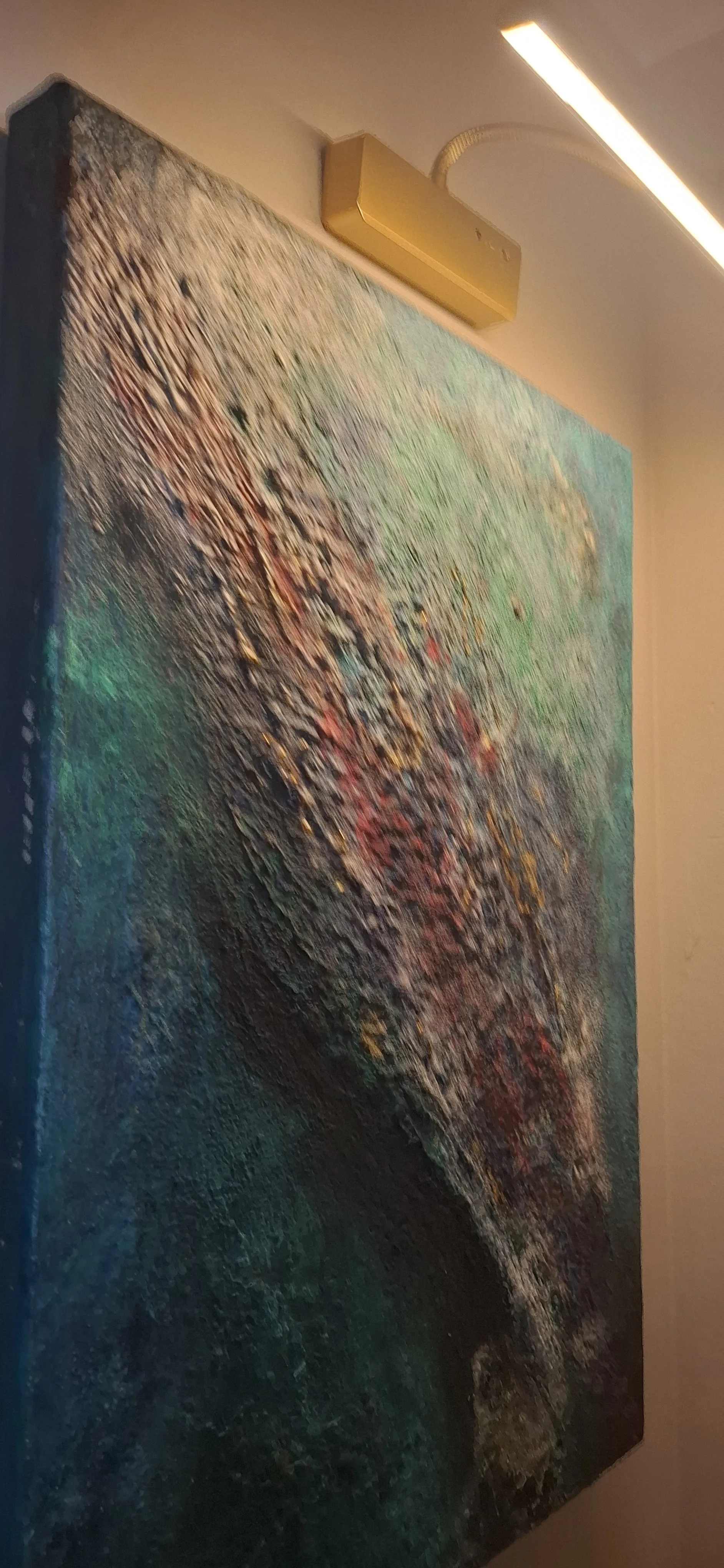 Ein abstrakes Gemälde mit bunten, strukturierte Texturen an einer Wand.